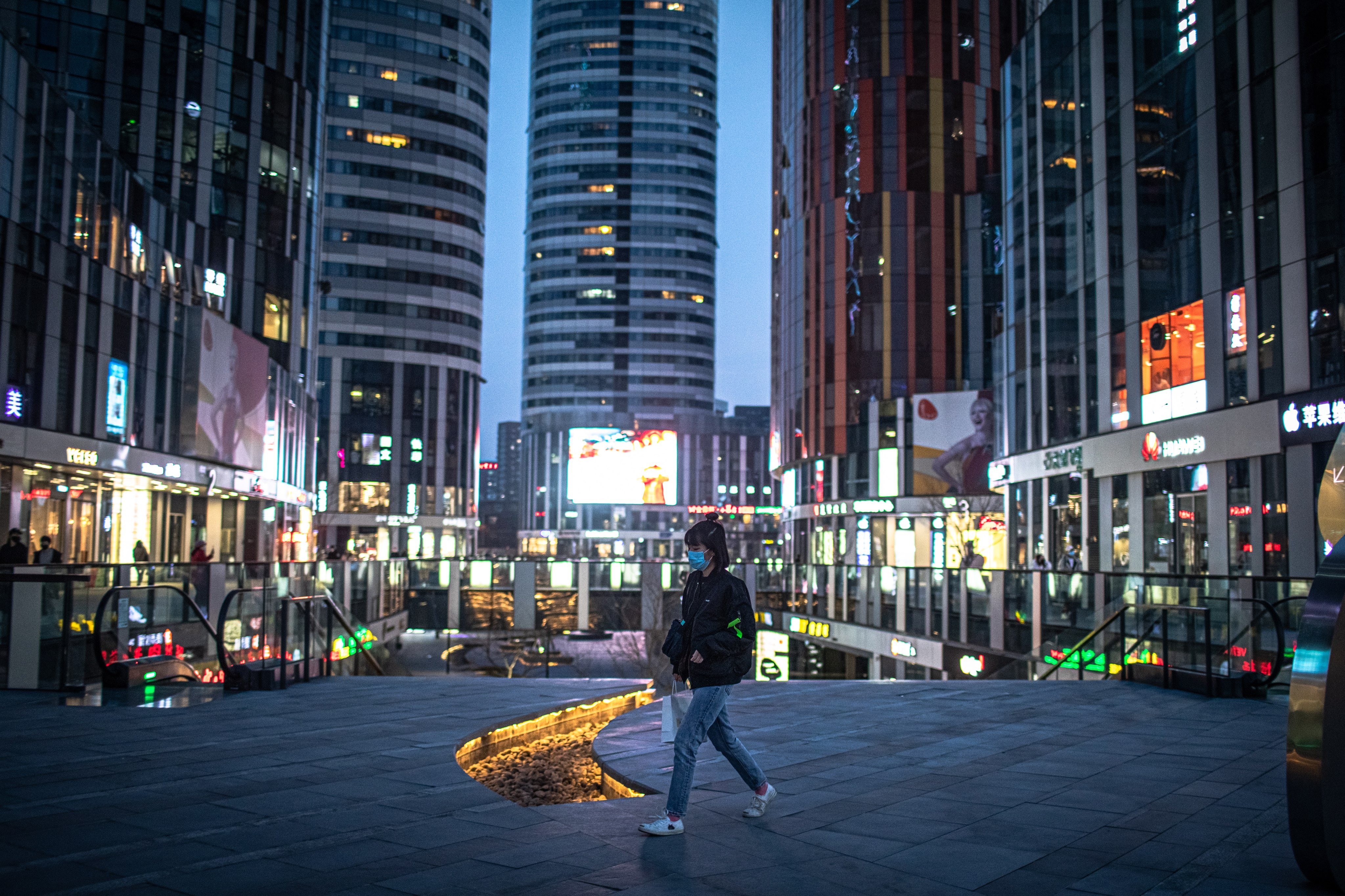A woman walks in the nearly deserted shopping area of Sanlitun in Beijing in 2020. Photo: EPA-EFE