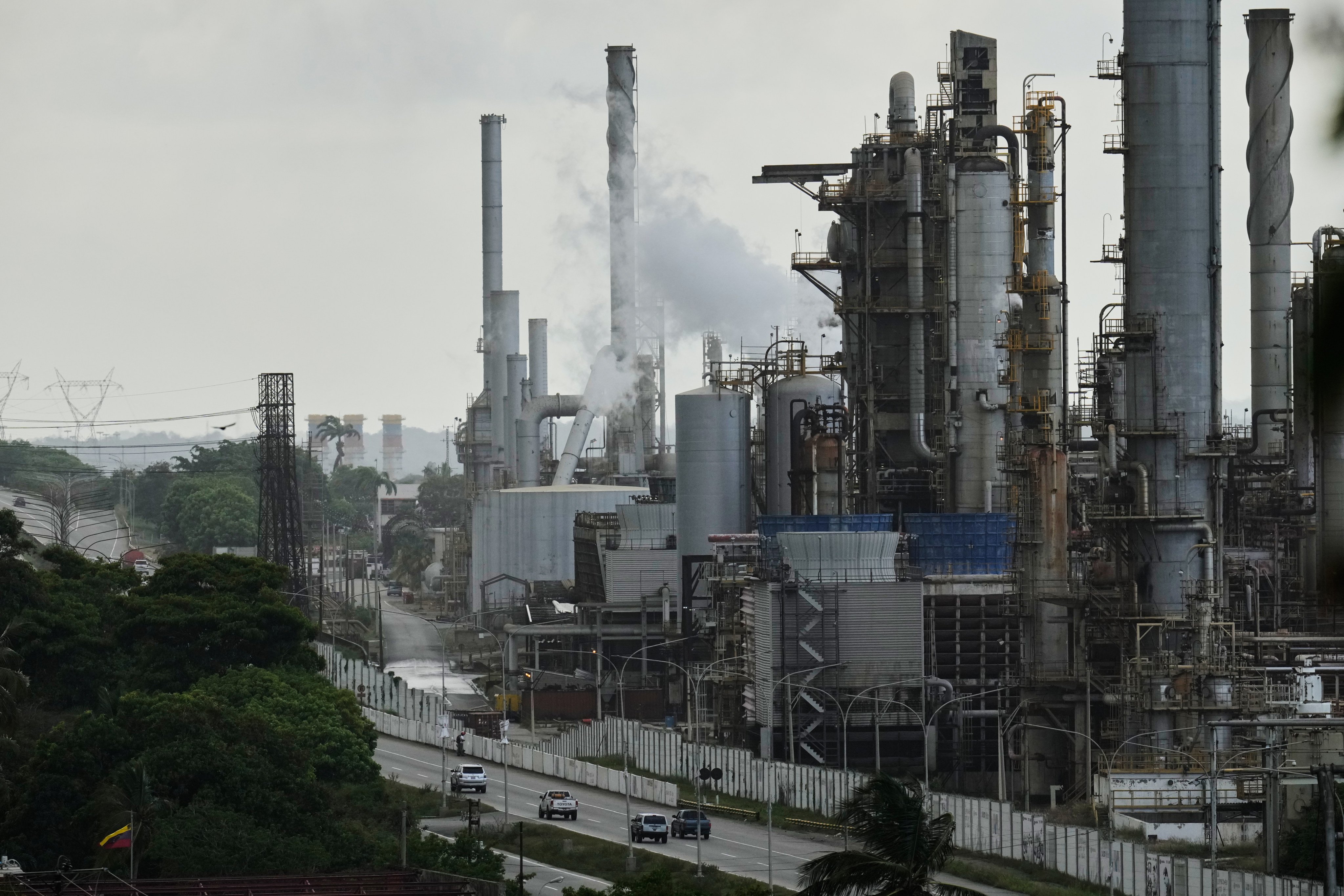 Vehicles drive past the El Palito refinery in Puerto Cabello, Venezuela. Photo: AP
