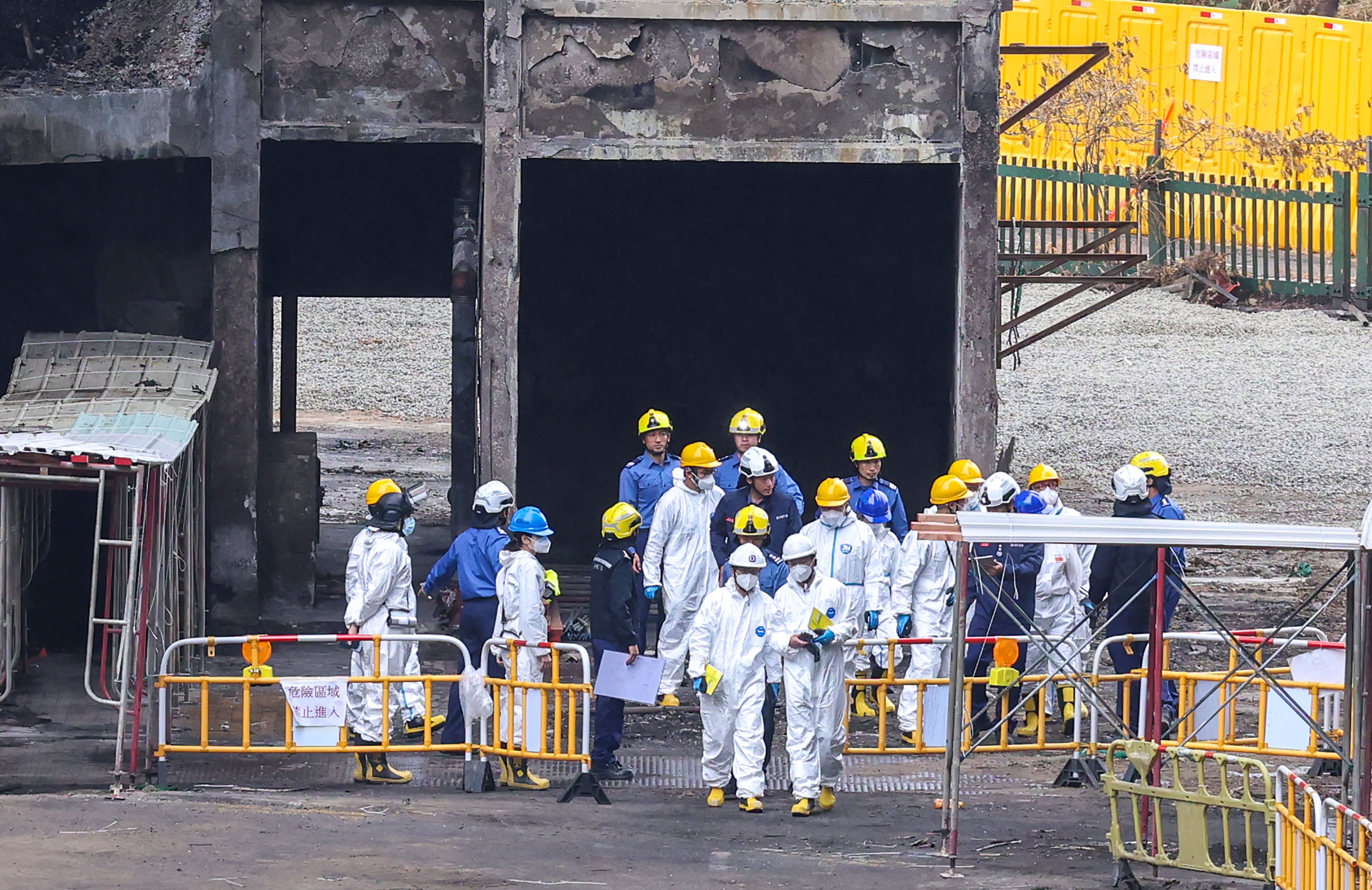 Members of the independent investigation committee of the Wang Fuk Court fire, wearing protective suits, inspect the fire scene on December 23. Photo: Jelly Tse