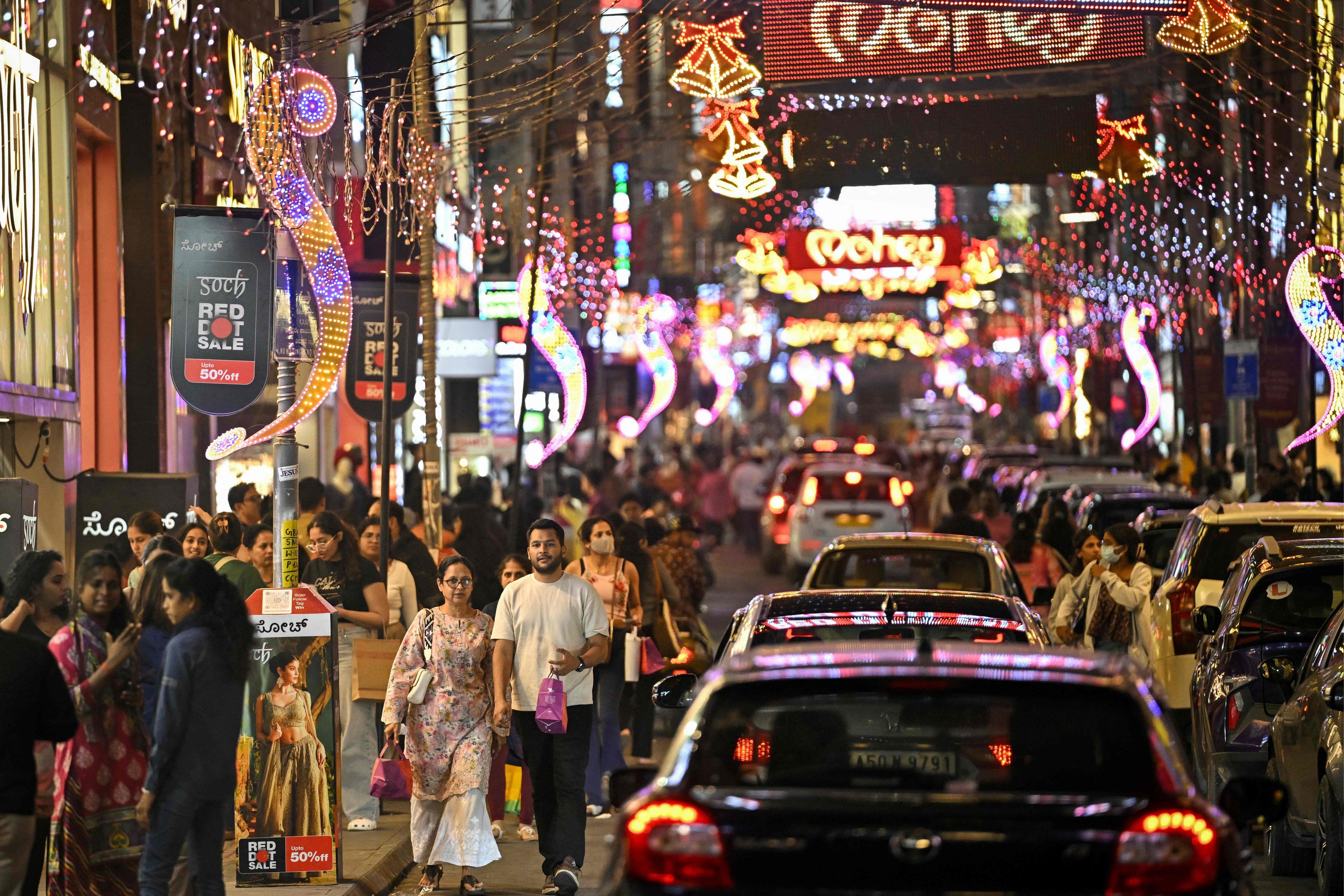 Shoppers walk along a street illuminated with decorative lights ahead of New Year celebrations in Bengaluru, India, last month. Photo: AFP