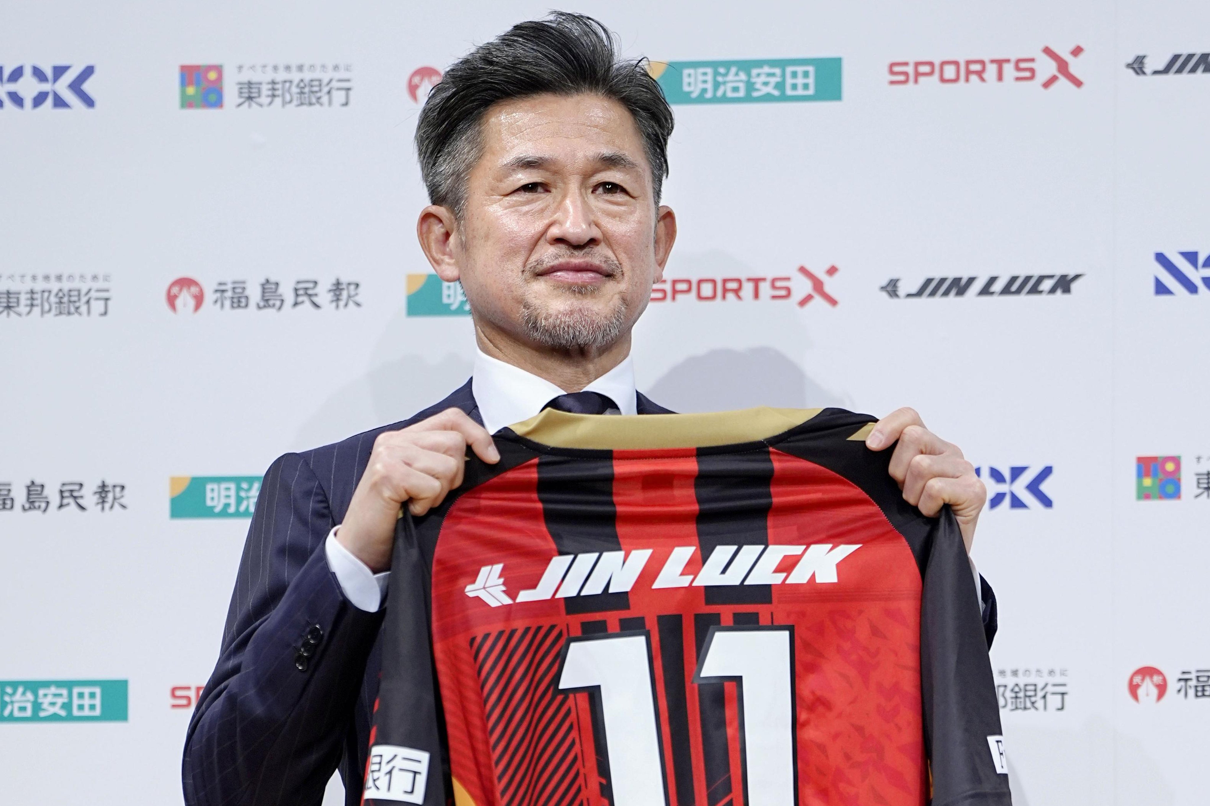 Kazuyoshi Miura poses with third division J-League team Fukushima United’s football top during a press conference. Photo: AP