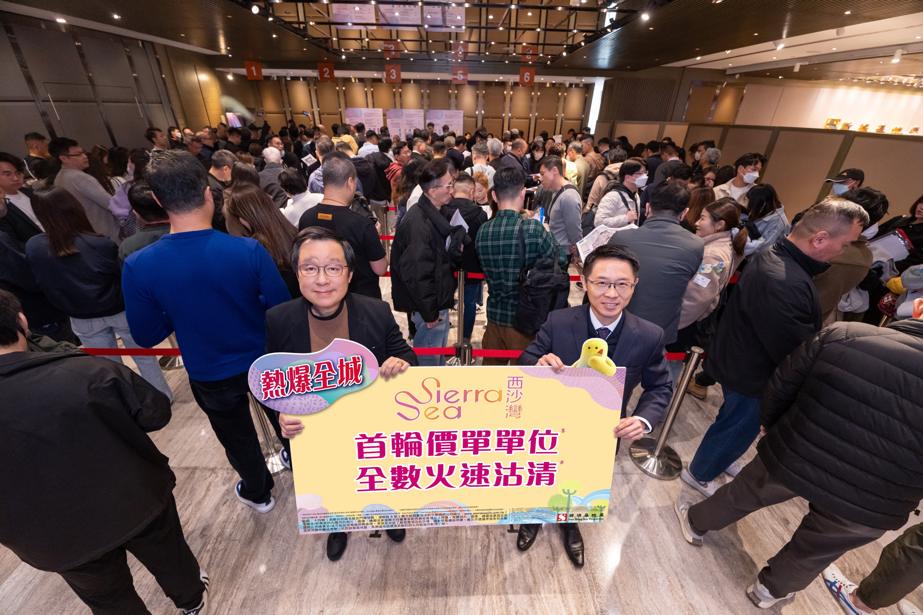 Sun Hung Kai Properties’ deputy managing director Victor Lui (left) and real state agency general manager Allen Woo hold a  banner marking the latest Sierra Sea sell-out. Photo: Handout