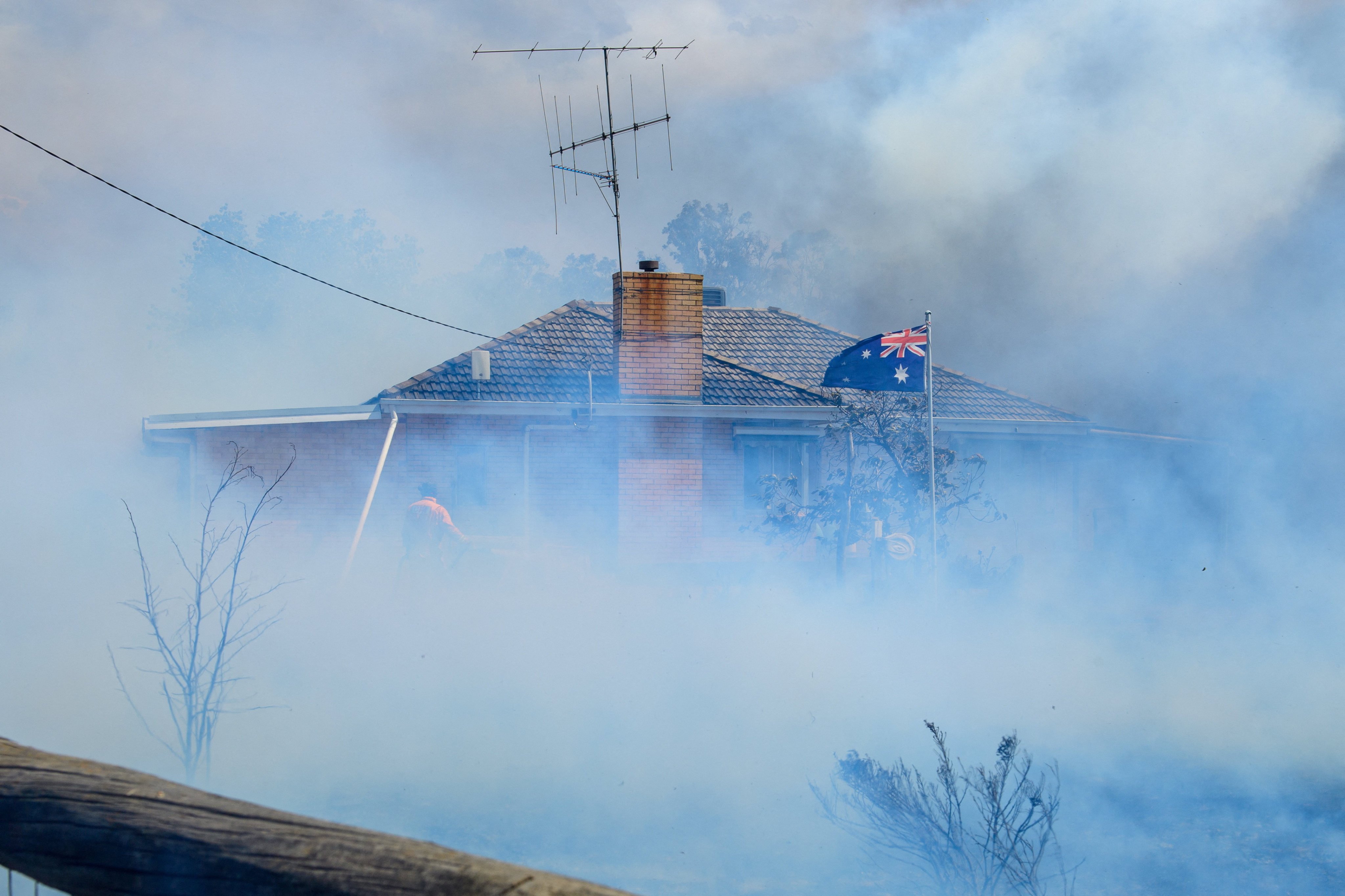 Smoke shrouds a home in Longwood, Australia’s Victoria state, on Friday as firefighters attempt to douse the flames. Photo: AAP/Reuters