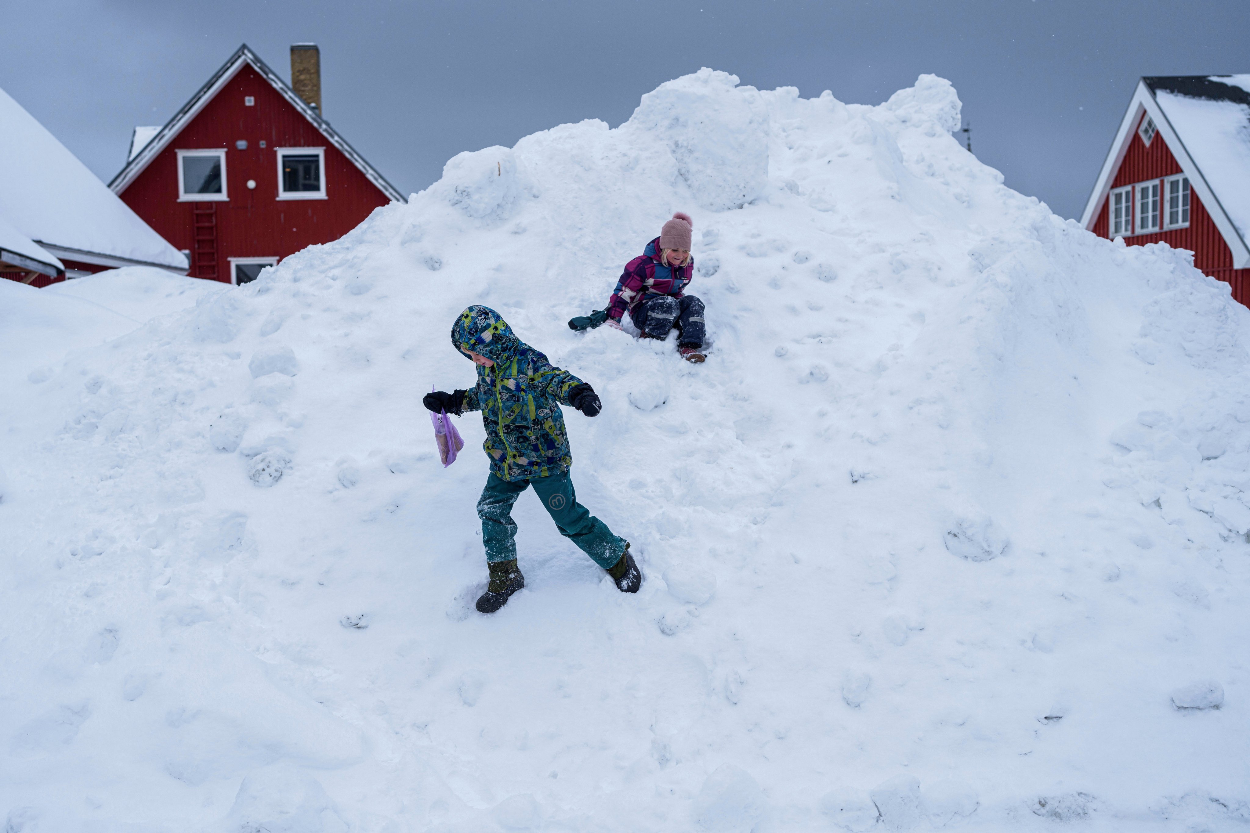 Children play in freshly fallen snow in Nuuk, Greenland, in March. Photo: AP