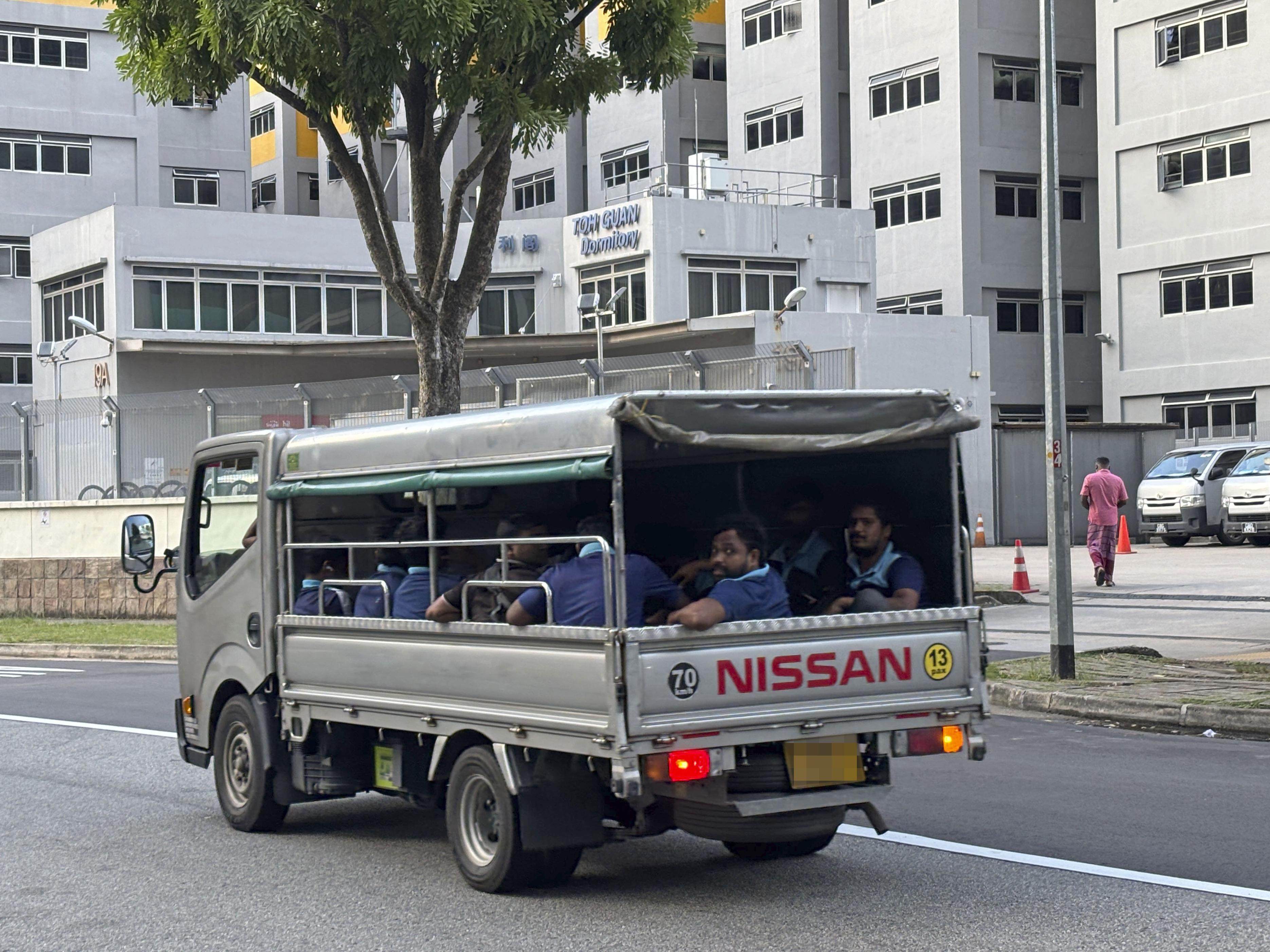 Migrant workers in the back of an open lorry in Singapore on December 6, 2025. Photo: Kyodo