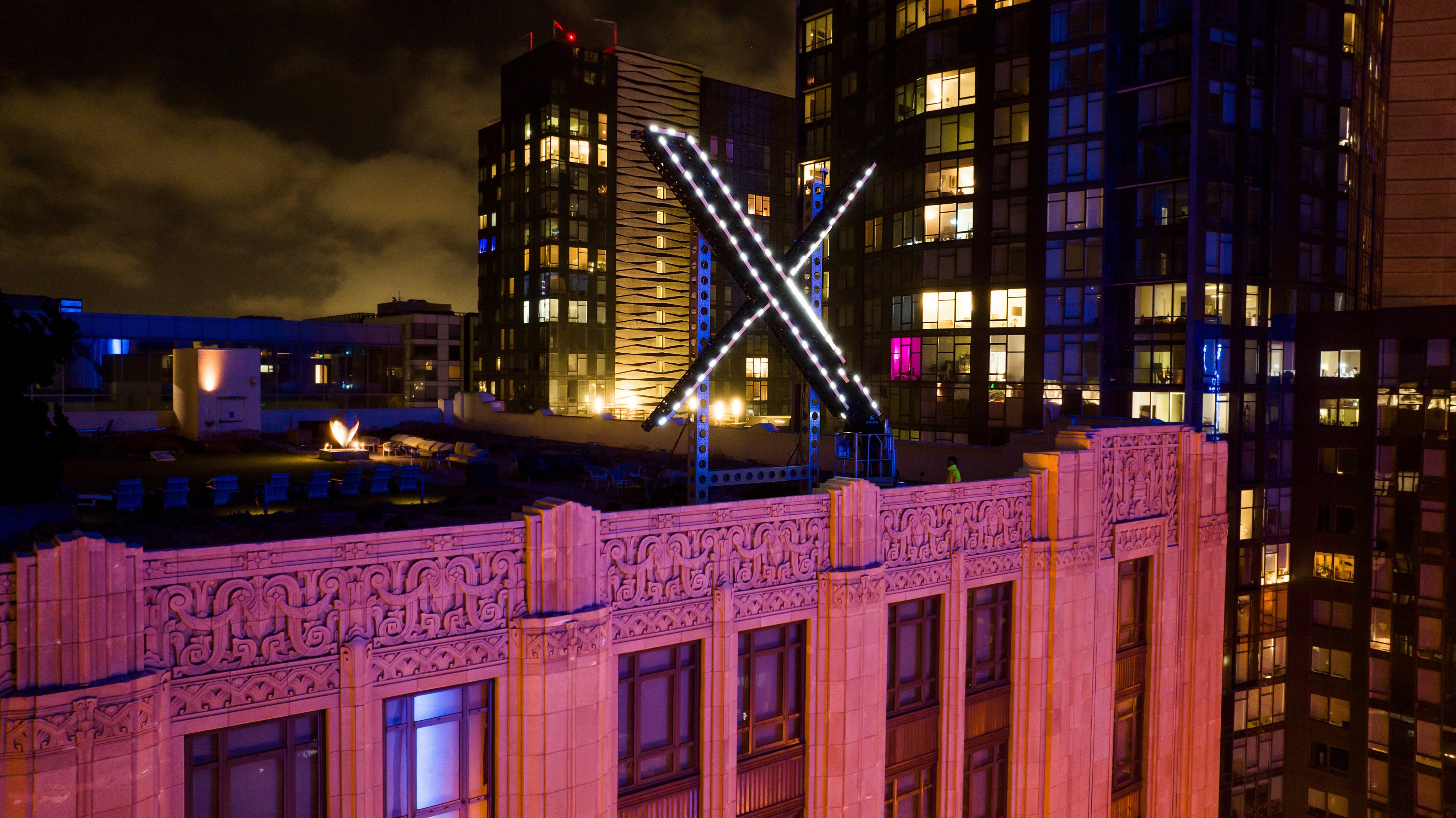 Workers install lighting on an ‘X’ sign atop the company headquarters, formerly known as Twitter, in downtown San Francisco in 2023. Photo: AP