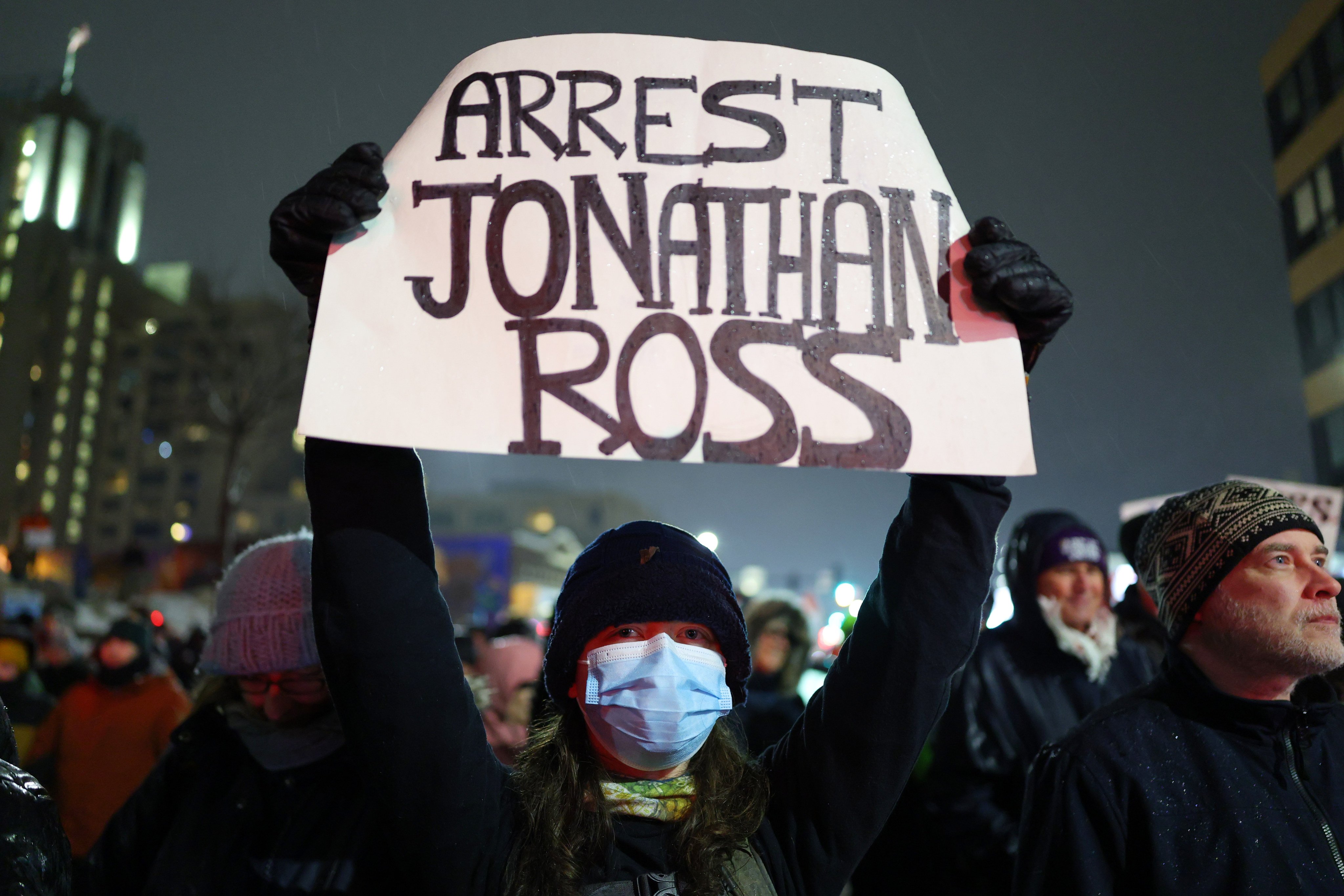 A protester holds a sign reading “Arrest Jonathan Rorss” during a rally for Renee Nicole Good in Minneapolis on Thursday. Photo: AP Photo