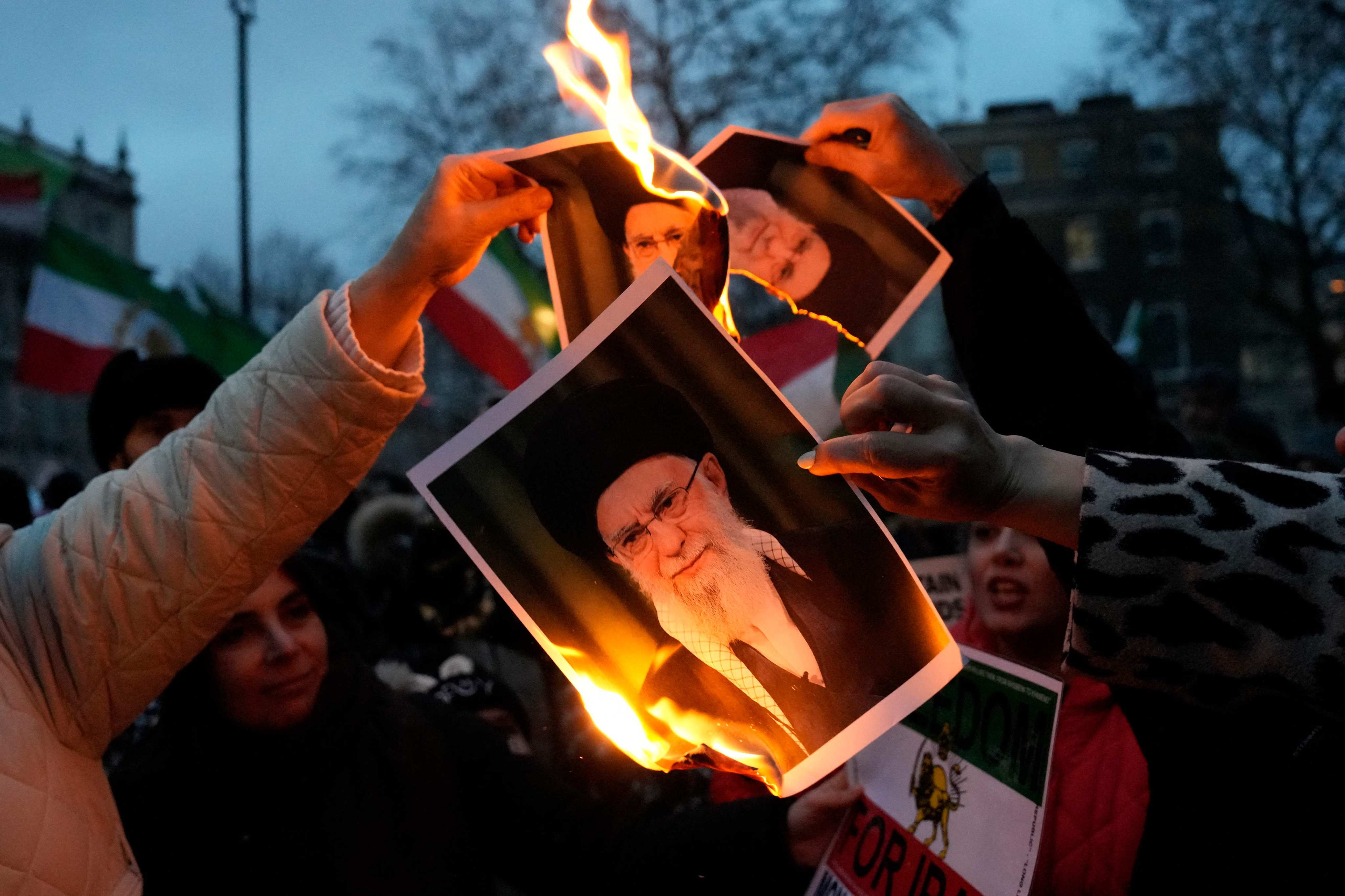 Protesters in London burn images of Iranian Supreme leader Ayatollah Ali Khamenei during a rally held on Sunday in solidarity with demonstrations in Iran. Photo: AFP