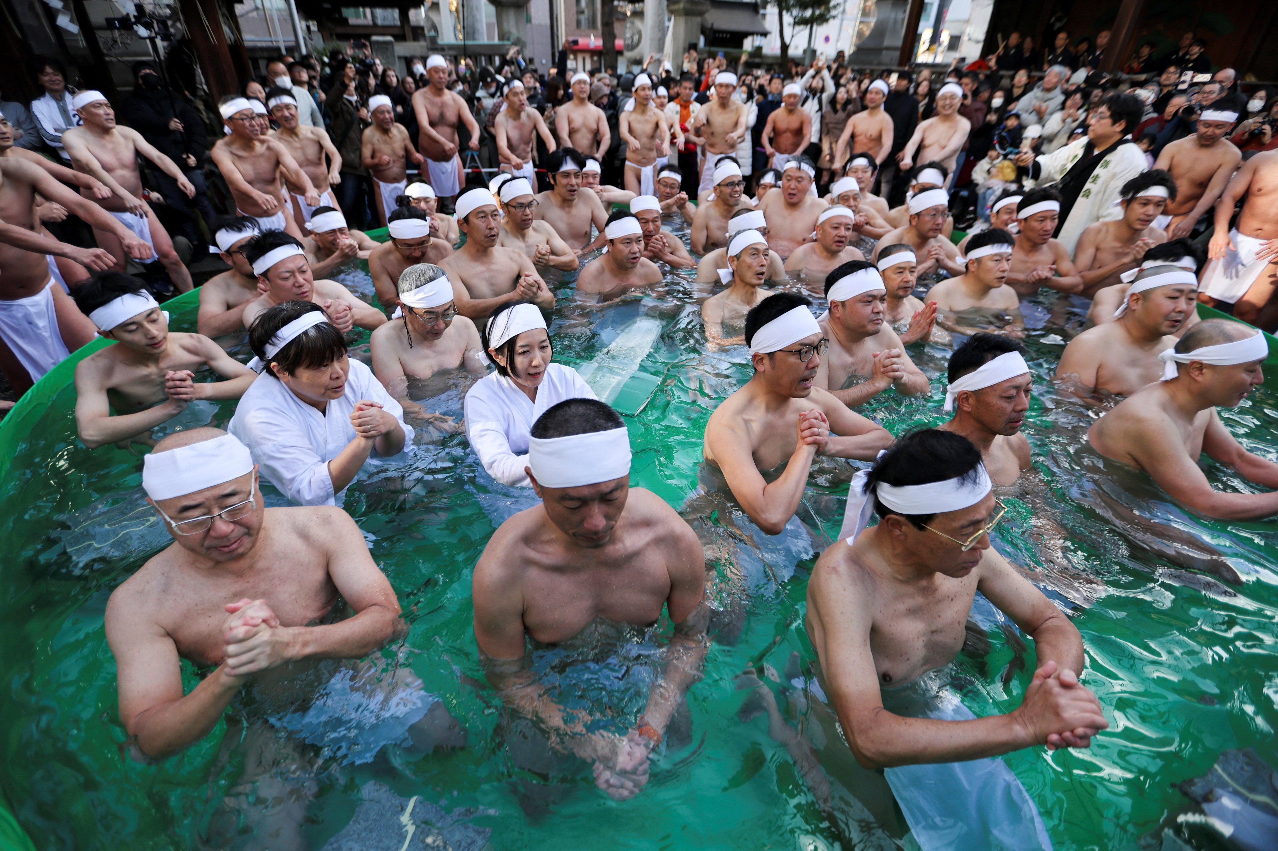 Participants pray as they take an ice-cold bath during a ceremony to purify their souls and to pray for the New Year at the Teppozu Inari shrine in Tokyo, Japan, January 11, 2026. REUTERS/Issei Kato