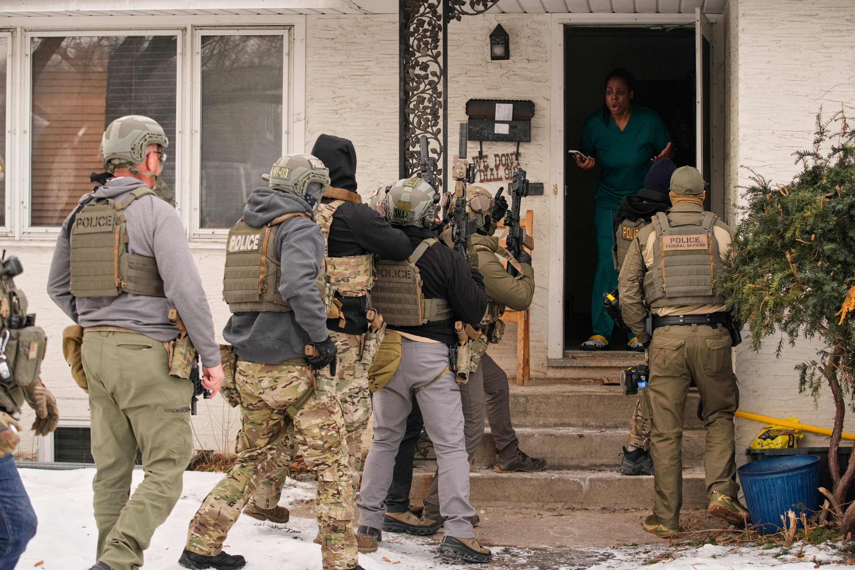 A woman reacts after a federal immigration officer used a battering ram to break down a door before making an arrest in Minneapolis on Sunday. Photo: AP