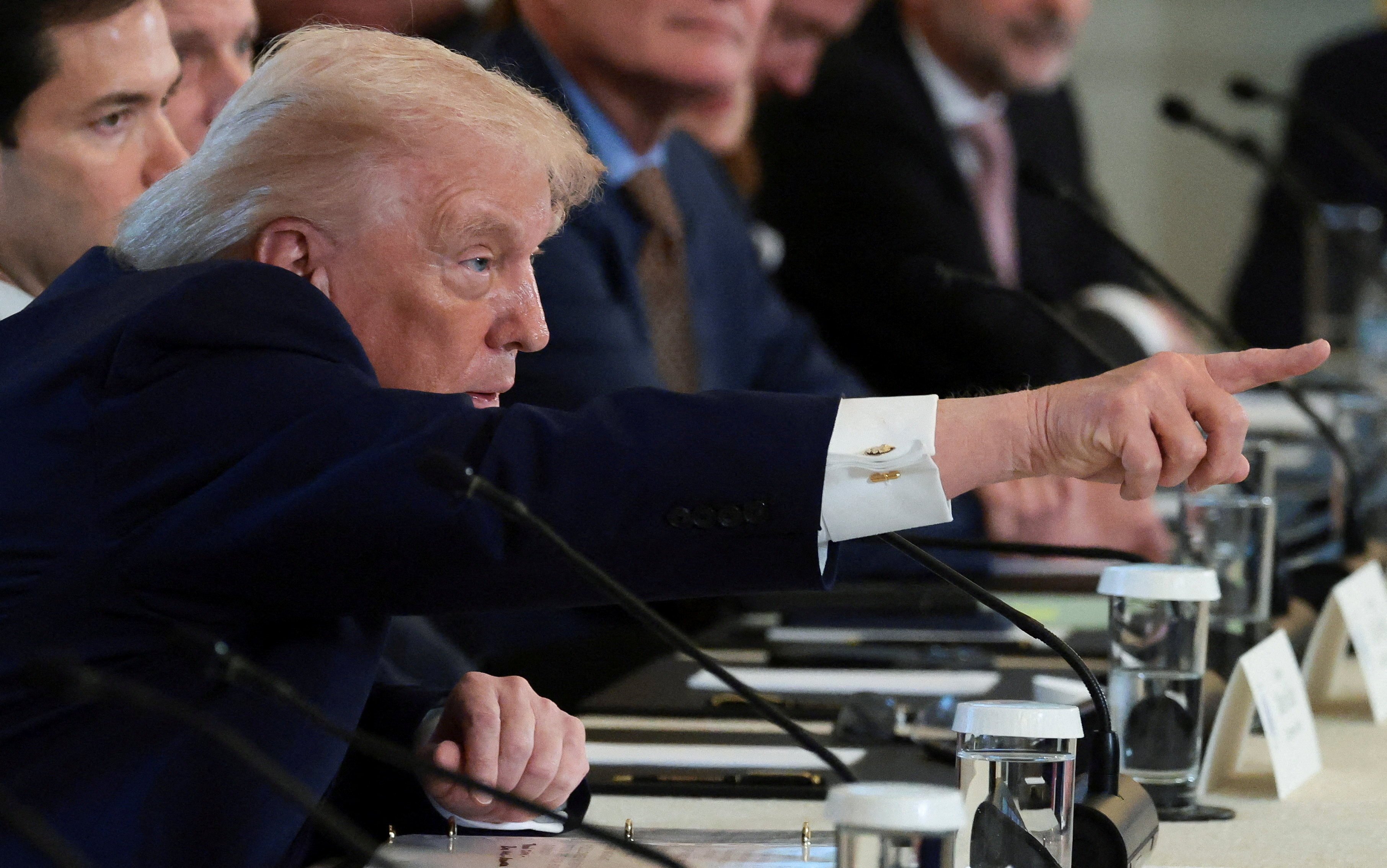 U.S. President Donald Trump points while sitting next to U.S. Secretary of State Marco Rubio as they attend a meeting with oil industry executives, at the White House in Washington, D.C., U.S., January 9, 2026. REUTERS/Evelyn Hockstein