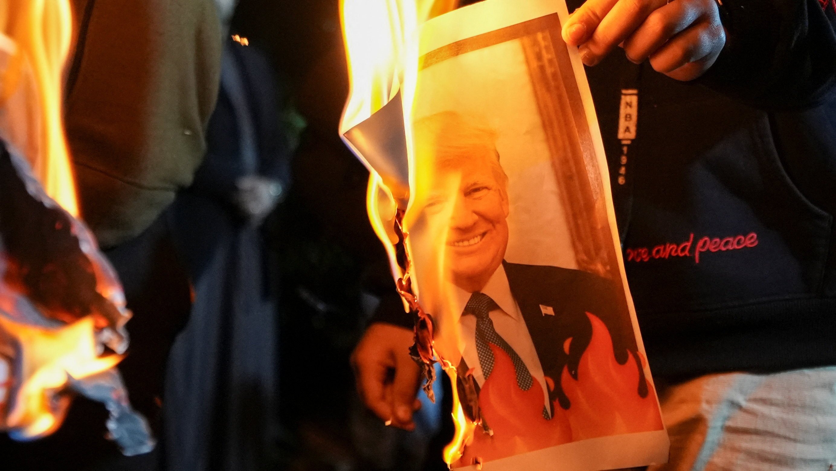 Iraqis burn an image of US President Donald Trump on Tuesday during a rally held in Basra in solidarity with Iran’s government. Photo: Reuters