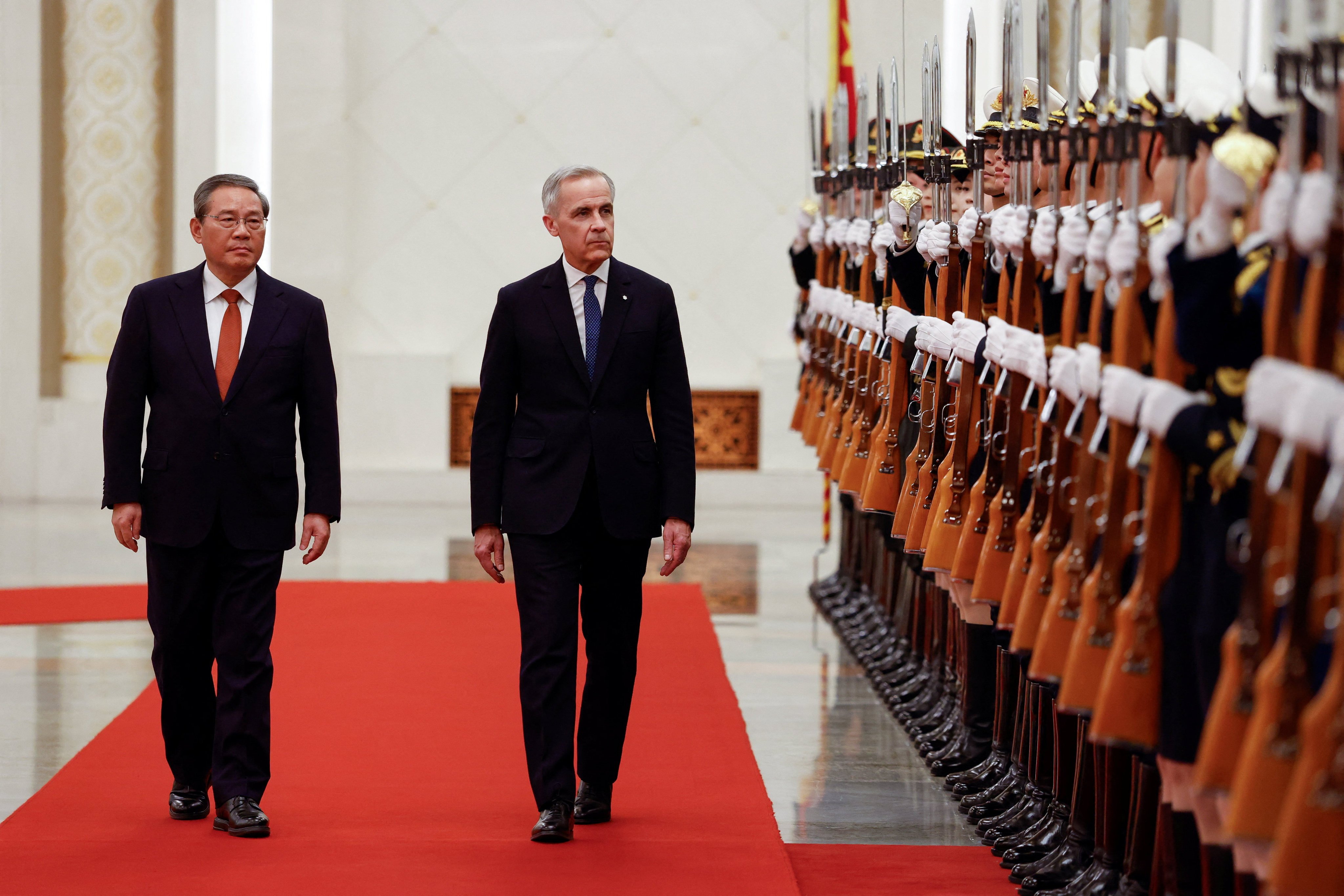 Chinese Premier Li Qiang and Canadian Prime Minister Mark Carney review an honour guard at the Great Hall of the People in Beijing on Thursday. Photo: Reuters