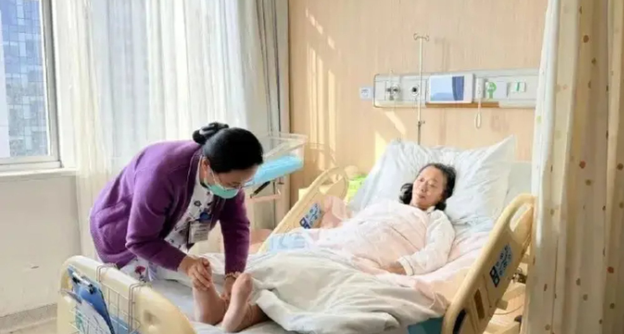 Zou, 59, receives a foot massage to relieve swelling as she lies in her hospital bed. Photo: Sohu