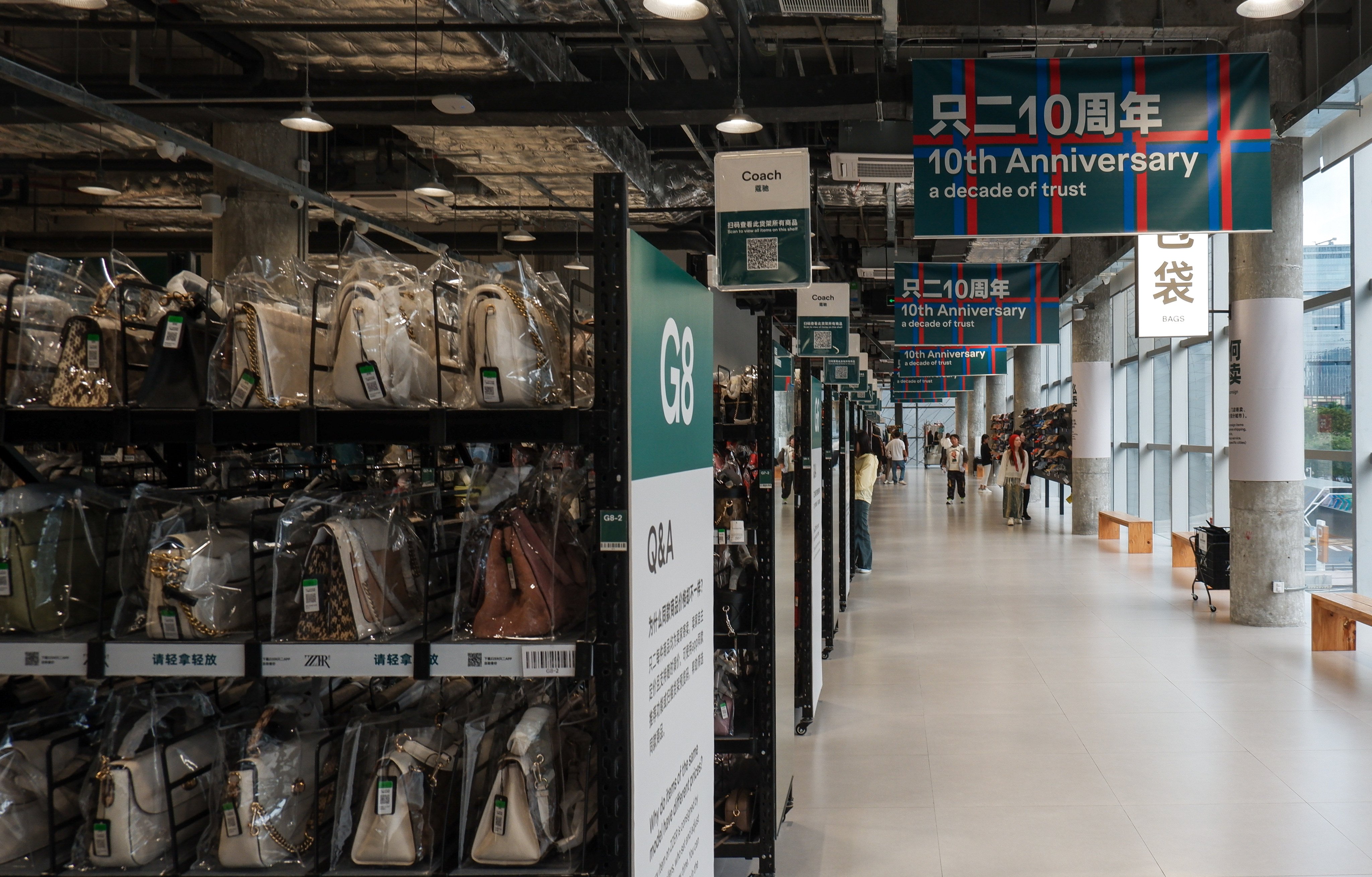 Second-hand luxury handbags at ZZER’s brick-and-mortar store in Shenzhen are organised by brand, with each bag displayed in a transparent case. Photo: Alice Li
