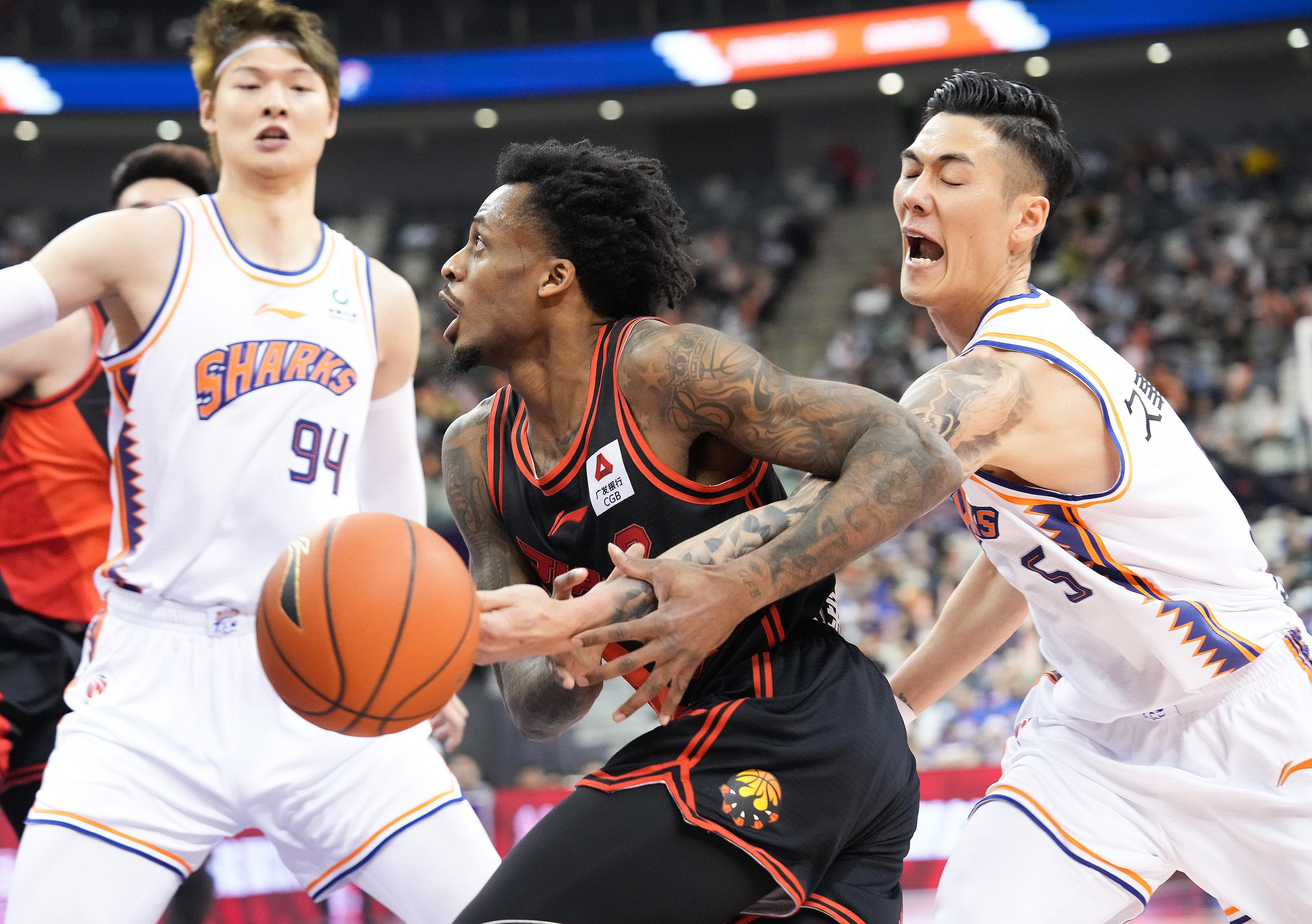 Antonio Blakeney (centre) of Jiangsu Dragons battles for the ball during a first round play-off match against Shanghai Sharks during the 2022-2023 season. Photo: Xinhua