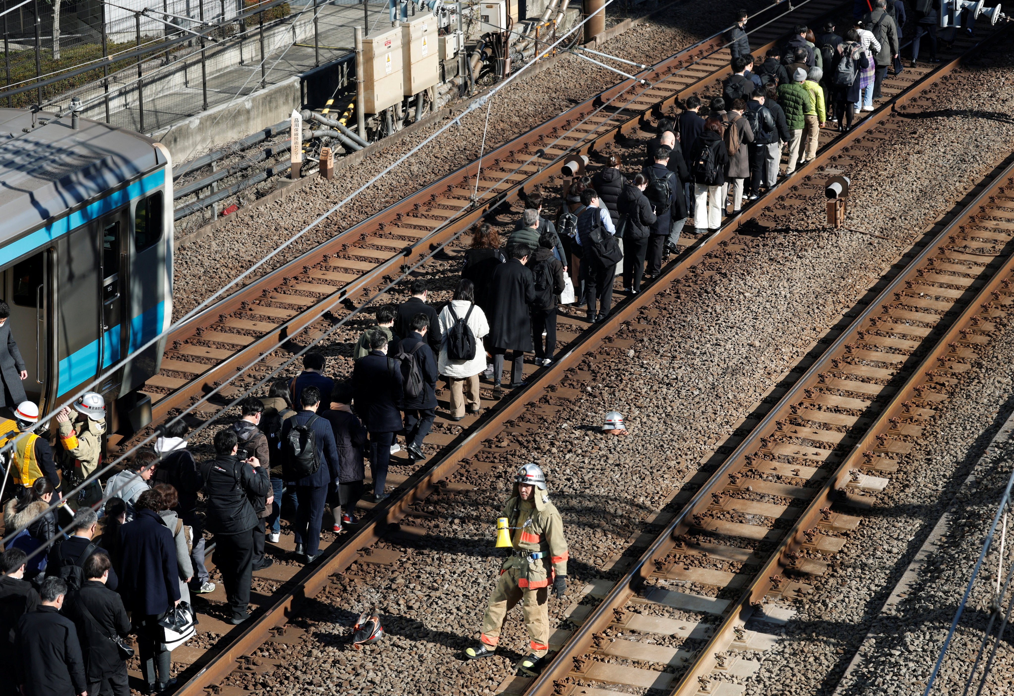 Passengers evacuated from a stranded train on the Keihin-Tohoku line walk to Tamachi station in Tokyo, Japan, January 16, 2026. REUTERS/Kim Kyung-Hoon