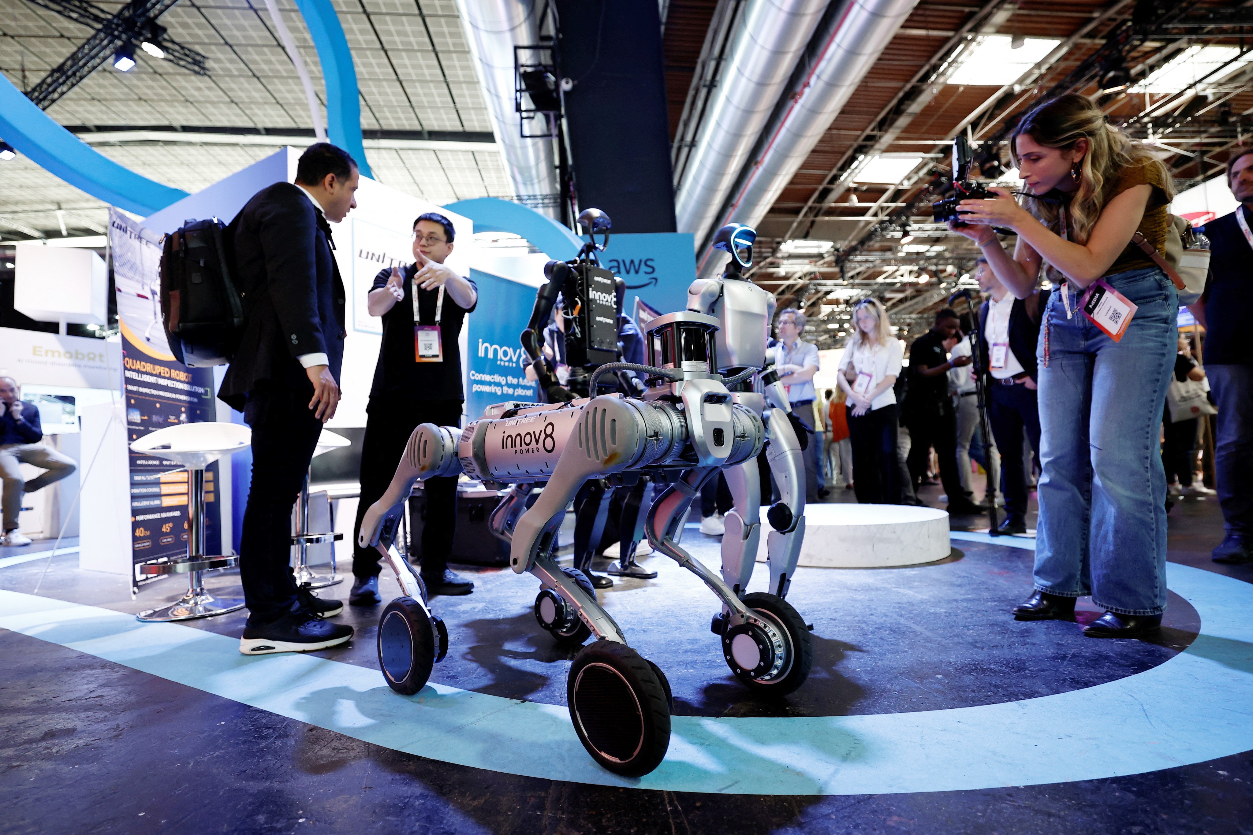Visitors take pictures of Unitree robots at a fair in Paris. Photo: Reuters