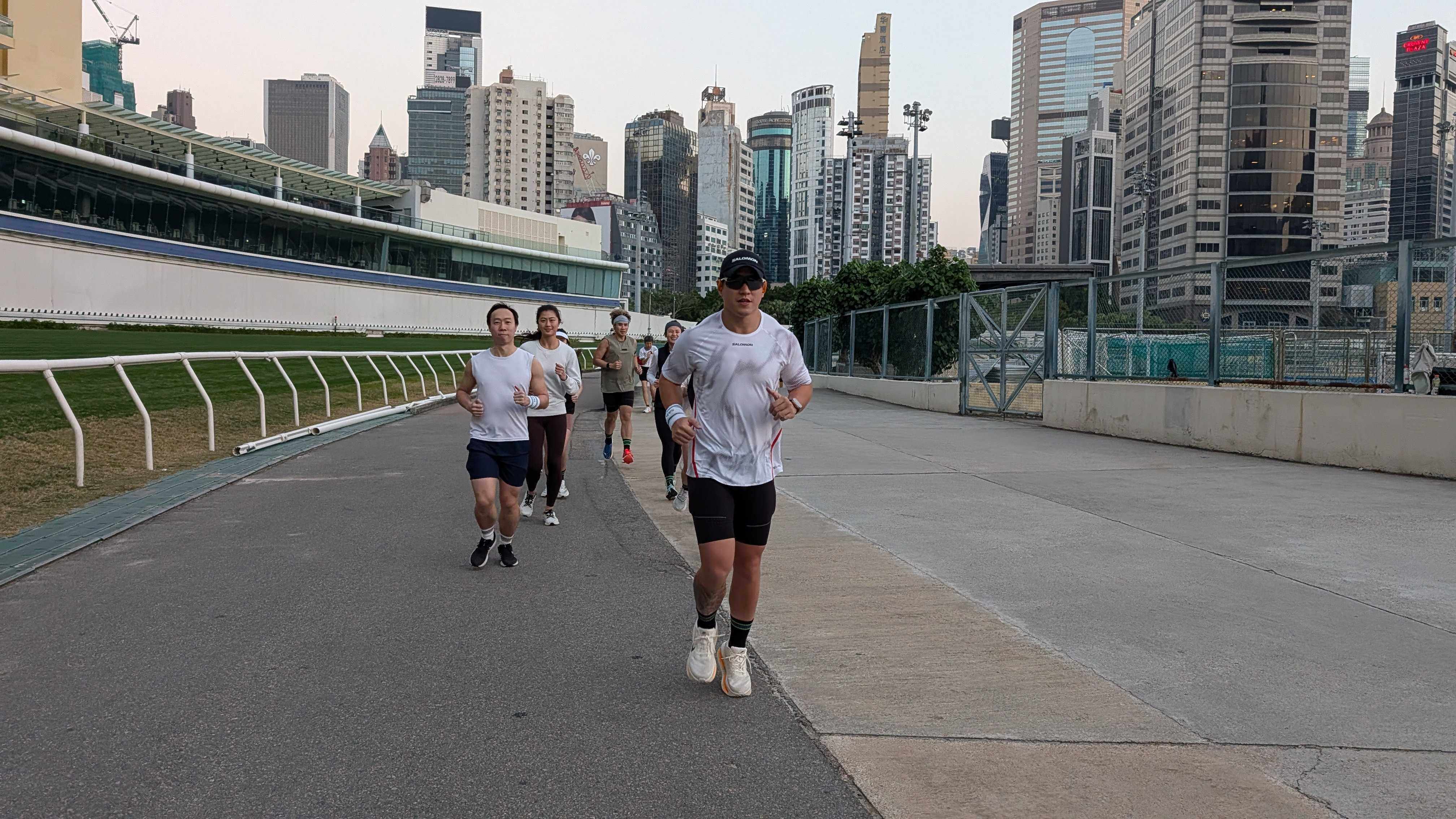 Trainer Michael Sik leads a small group of running enthusiasts around the outer track at Happy Valley Racecourse. Photo: Chieu Luu