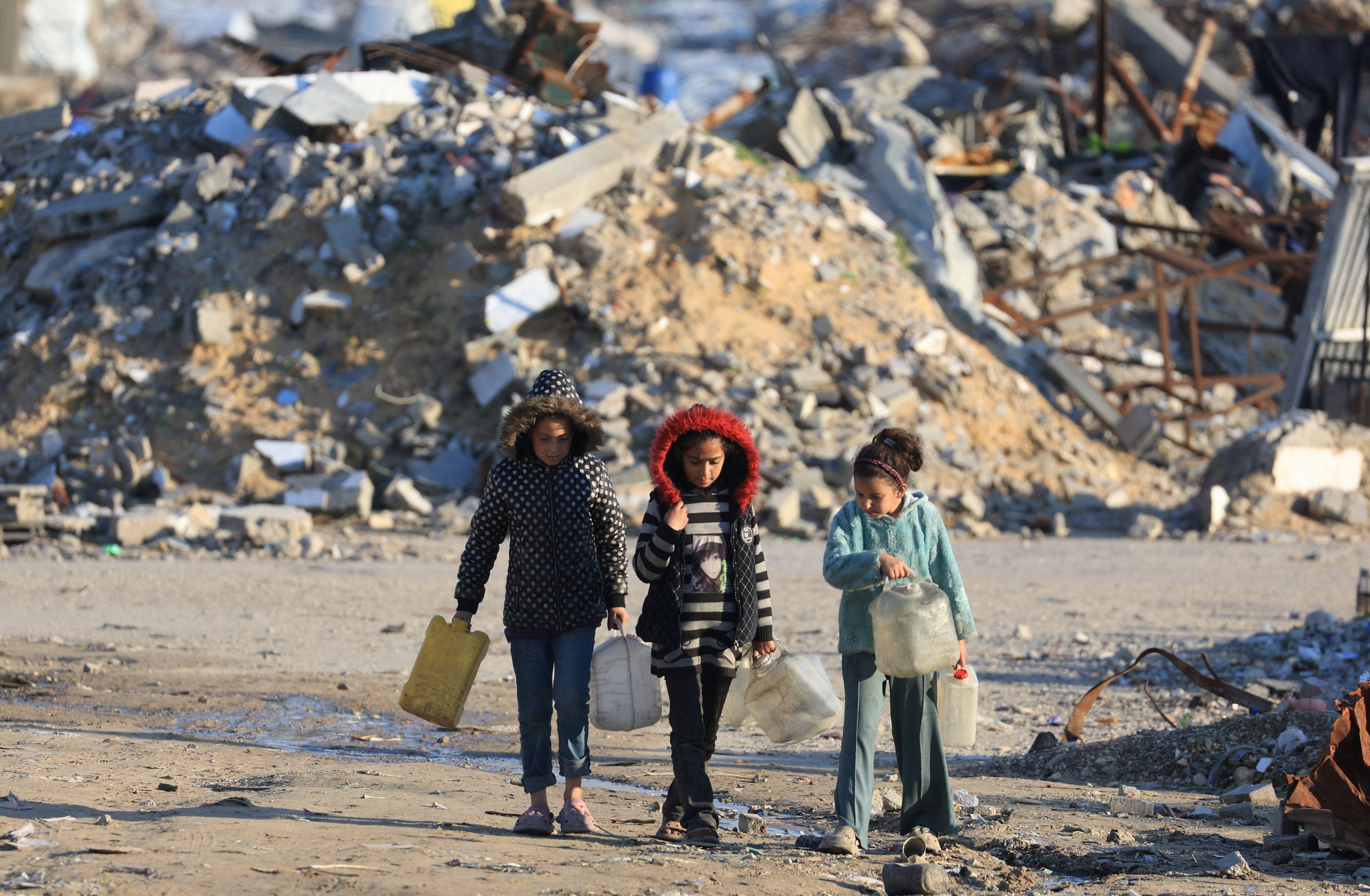 Palestinian girls walk past the rubble of residential buildings destroyed during the war in Gaza City on Friday. Photo: Reuters