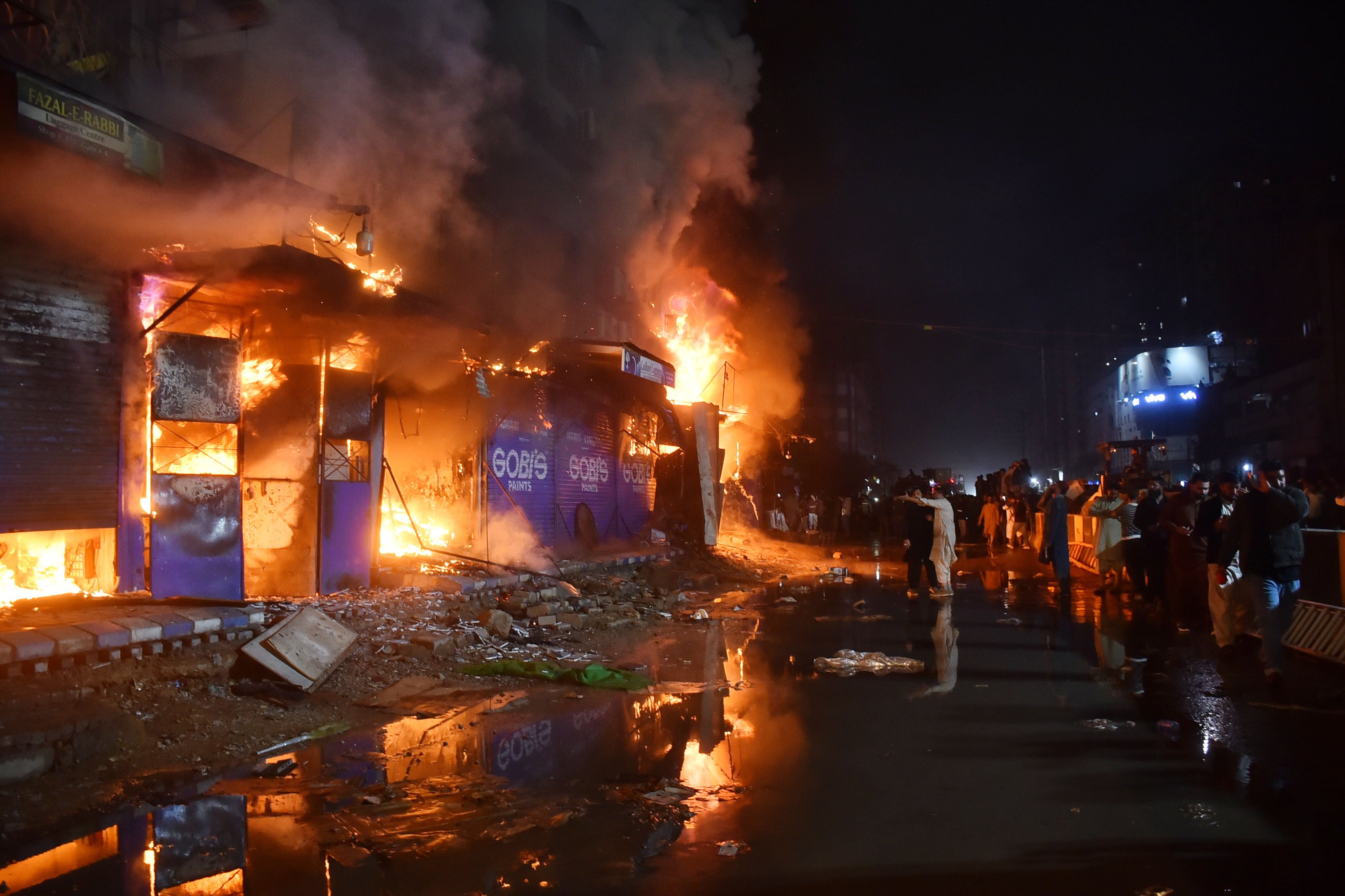 Locals gather to observe a massive fire sweeping through a shopping mall in Karachi on Sunday. Photo: Xinhua