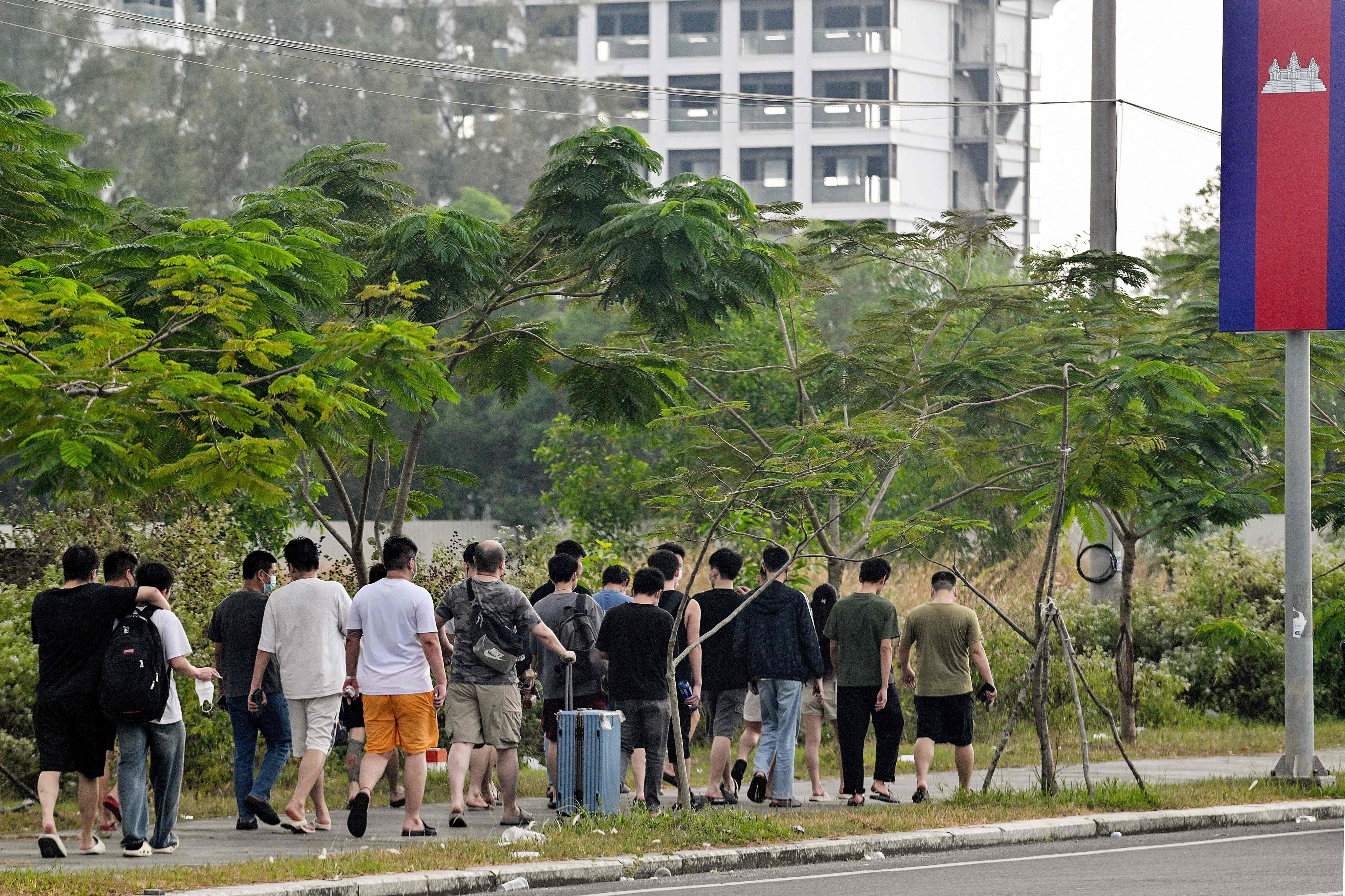 Workers walk out of a suspected scam compound in Sihanoukville on January 15, after Chen Zhi, the alleged kingpin of one of Asia’s largest cyber scam organisations, was arrested in Cambodia and sent to China. Photo: AFP