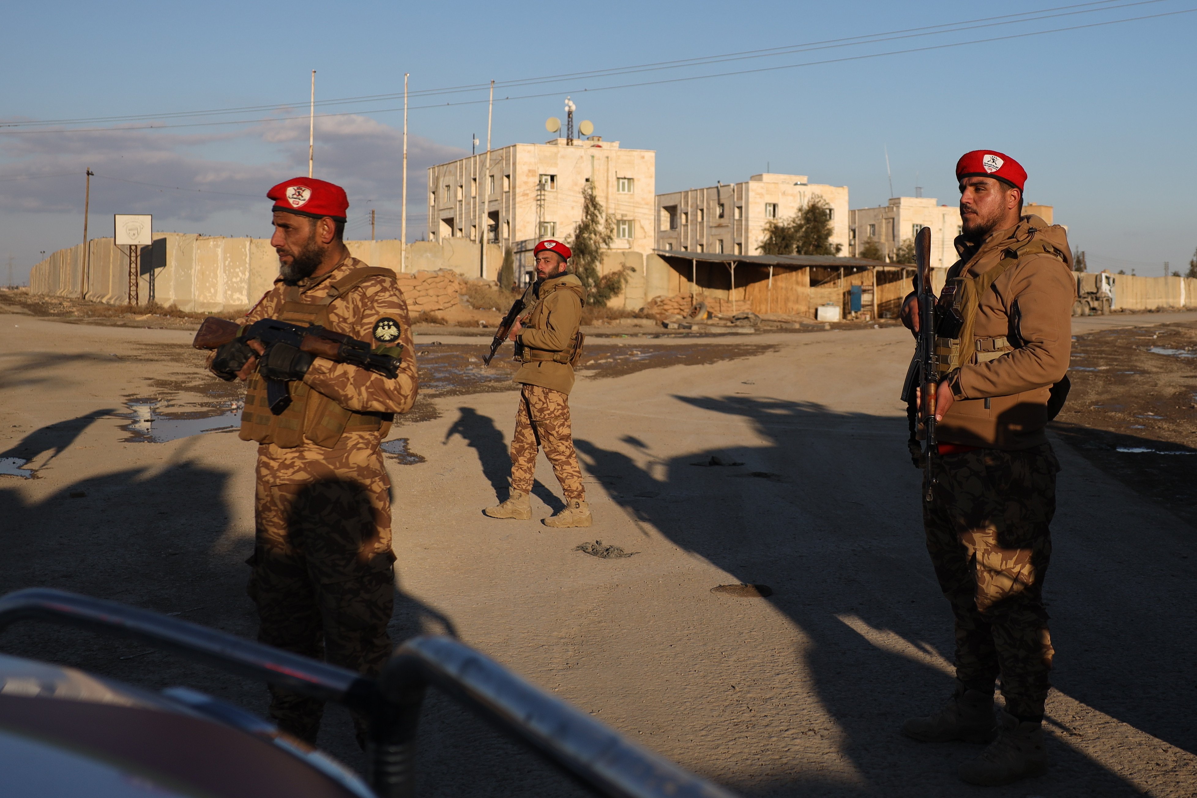 Syrian government forces stand guard outside al-Aqtan prison on the outskirts of Raqqa, northeastern Syria, amid prison breaks and clashes on Monday. Photo: AP