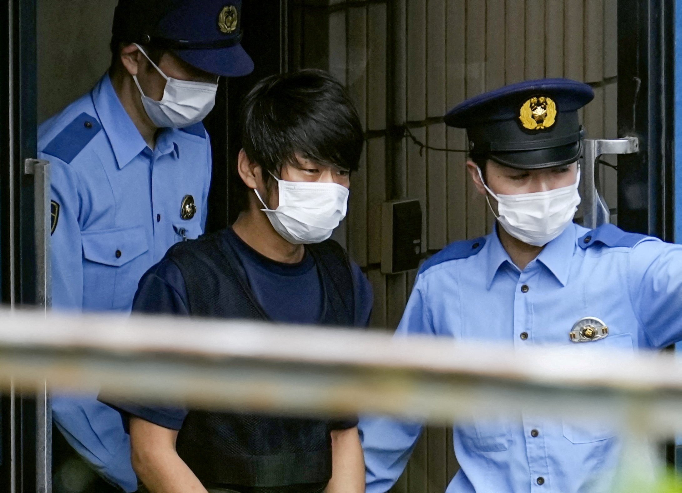 Tetsuya Yamagami, suspected of killing former Japanese premier Shinzo Abe, is escorted by police officers as he is taken to prosecutors, at Nara-nishi police station in Nara, western Japan, in this photo taken by Kyodo July 10, 2022. Mandatory credit Kyodo via REUTERS ATTENTION EDITORS - THIS IMAGE WAS PROVIDED BY A THIRD PARTY. MANDATORY CREDIT. JAPAN OUT. NO COMMERCIAL OR EDITORIAL SALES IN JAPAN. NO RESALES. NO ARCHIVES