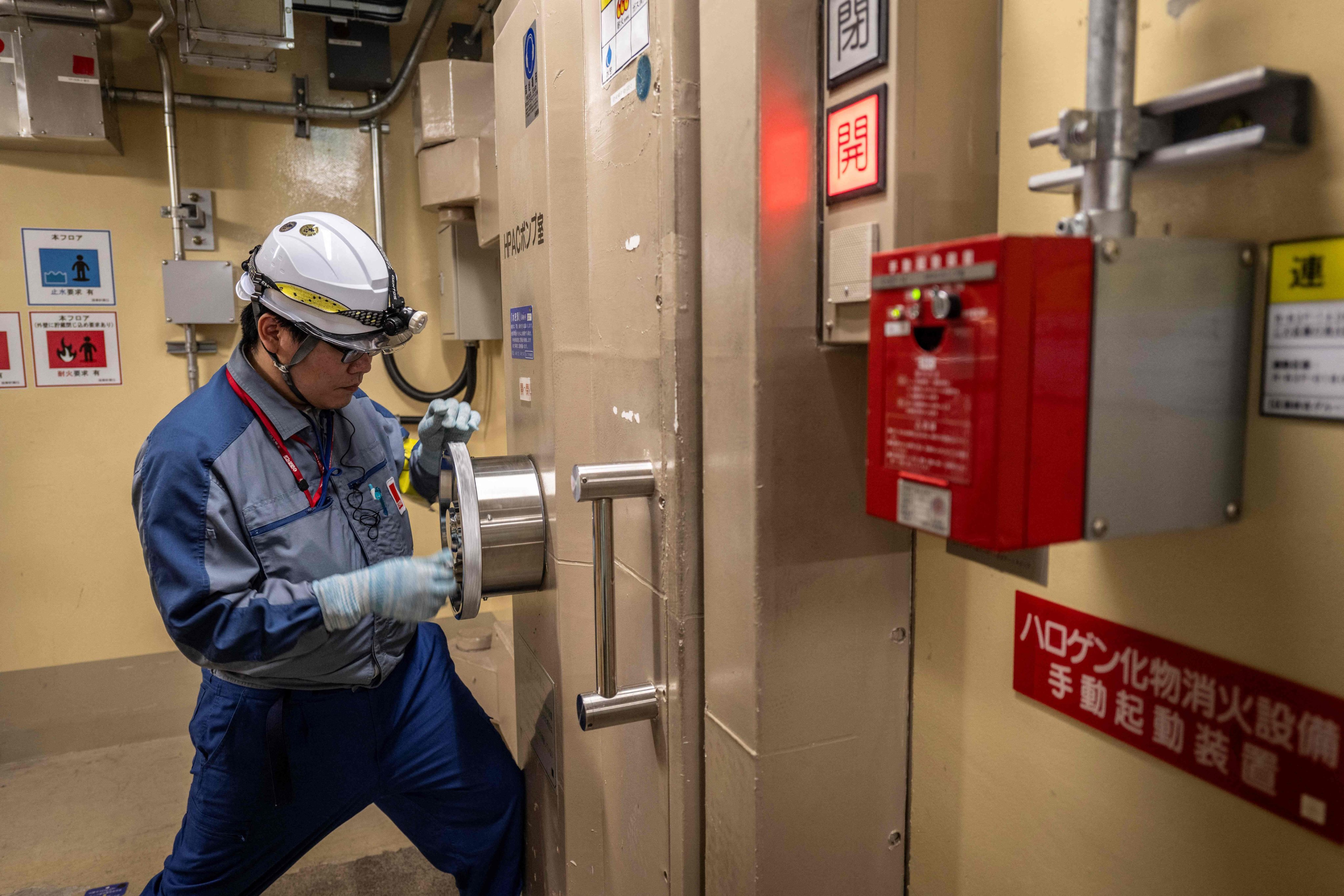 A Tepco employee opens a watertight door inside the unit 7 reactor building at the Kashiwazaki-Kariwa nuclear power station in August 2024. Photo: AFP