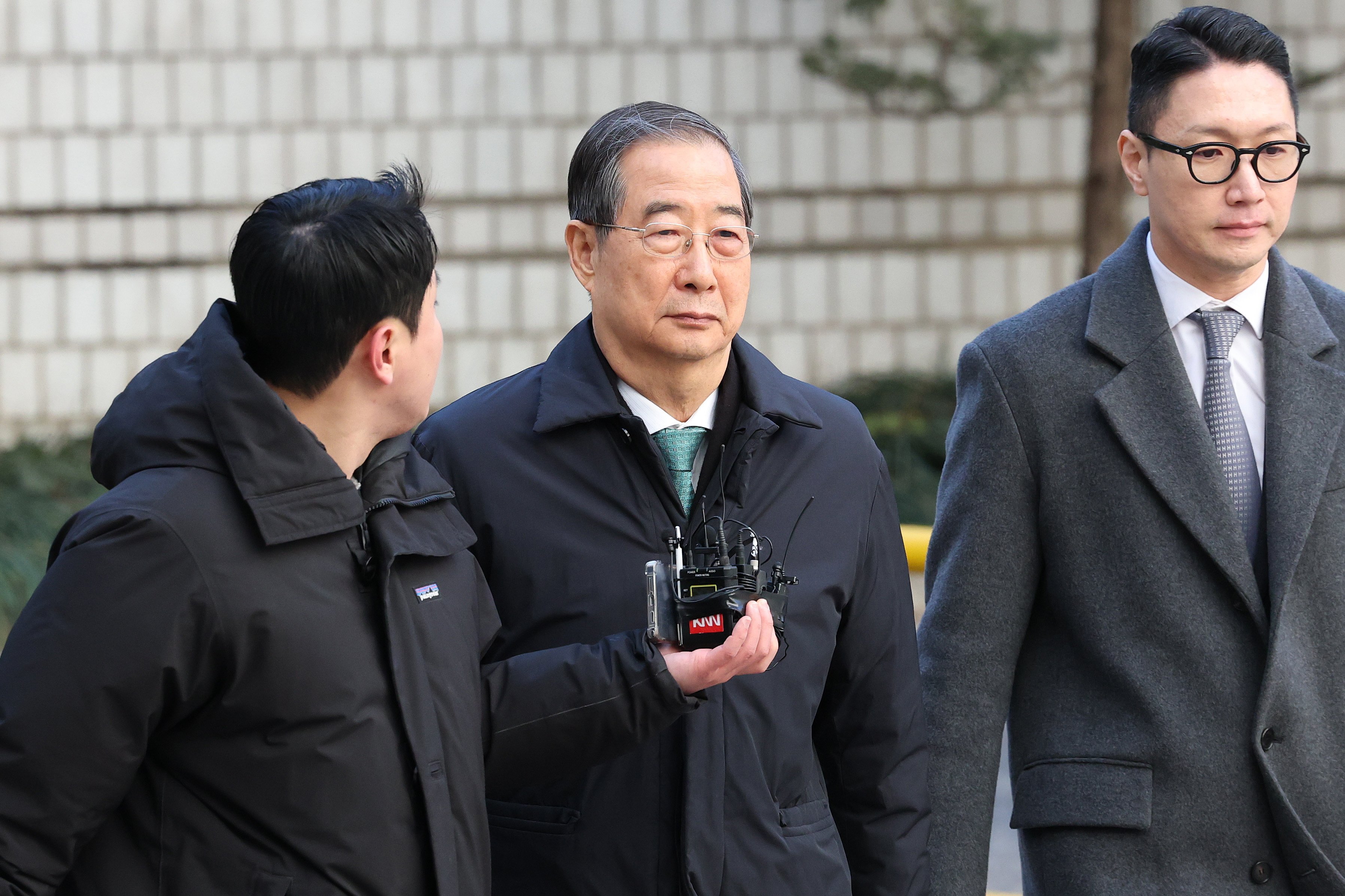 Former South Korean prime minister Han Duck-soo (right) is questioned by a reporter as he arrives at the Seoul Central District Court on Wednesday. Photo: EPA
