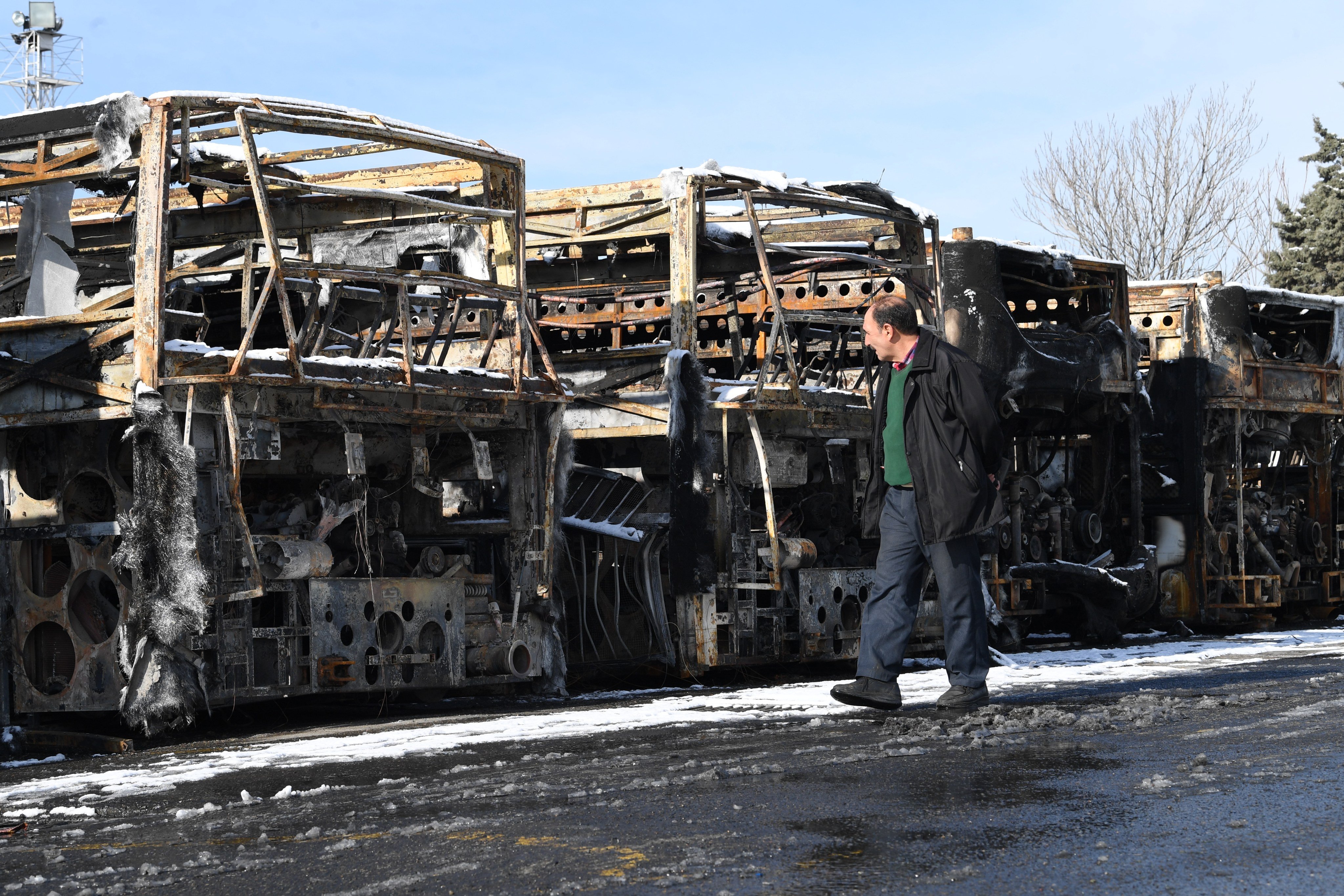 A man passes by buses destroyed in Tehran during recent unrest in Iran. Photo: Xinhua