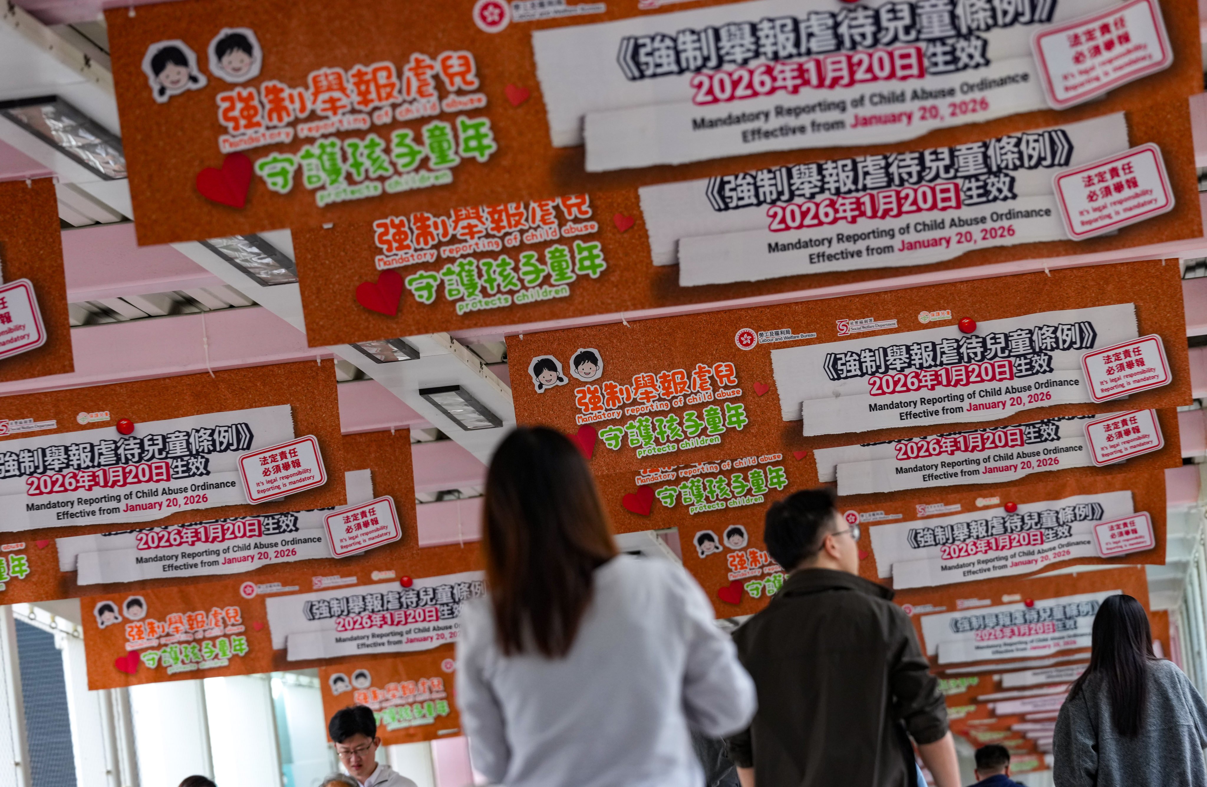 Posters for the Mandatory Reporting of Child Abuse Ordinance along a footbridge in Admiralty on January 20. Photo: Jelly Tse