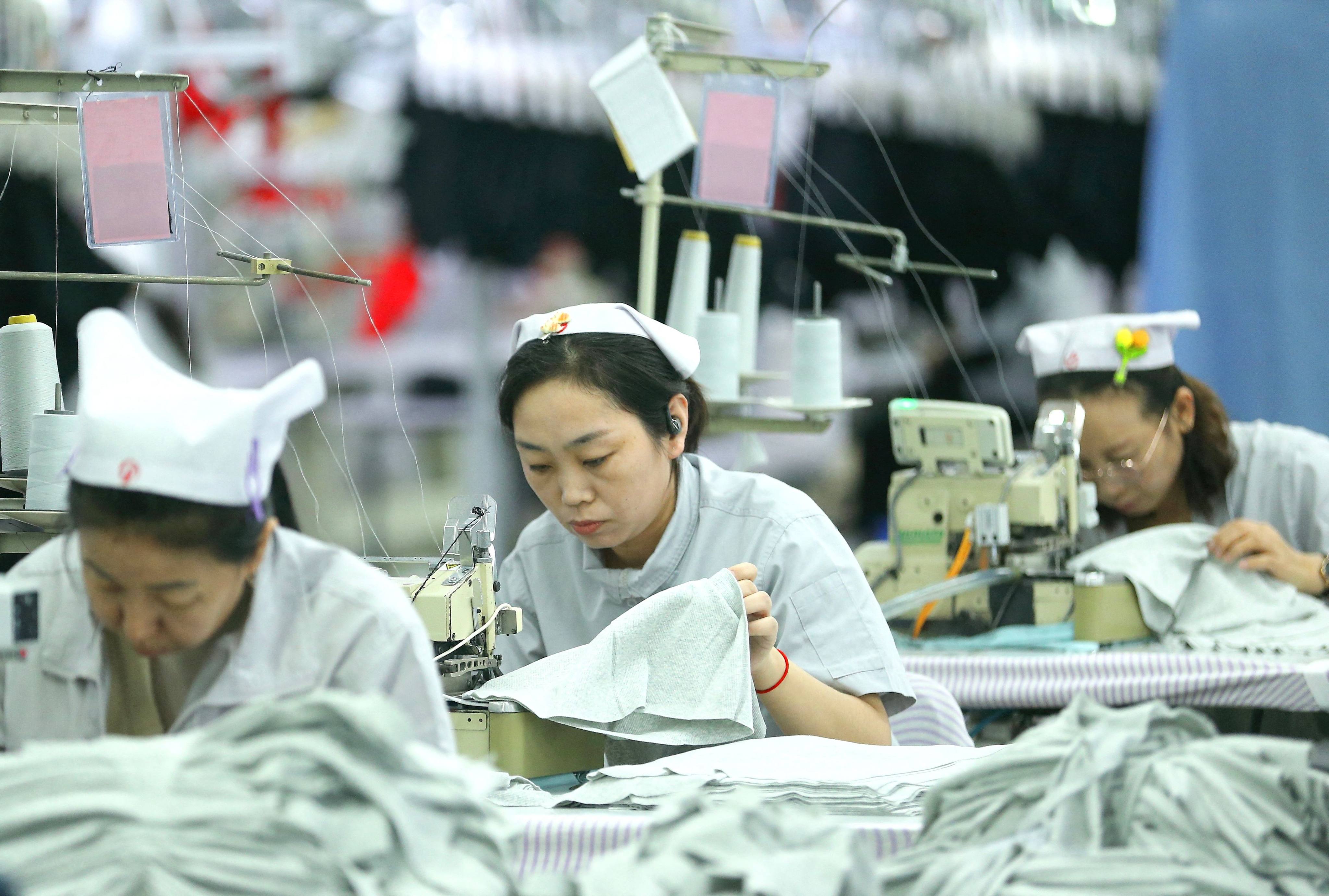 Workers sew garments at a textile factory in Qingdao, in eastern China’s Shandong province on December 15, 2025. As provinces raise the minimum wage, low-paid workers will see the most benefit. Photo: AFP