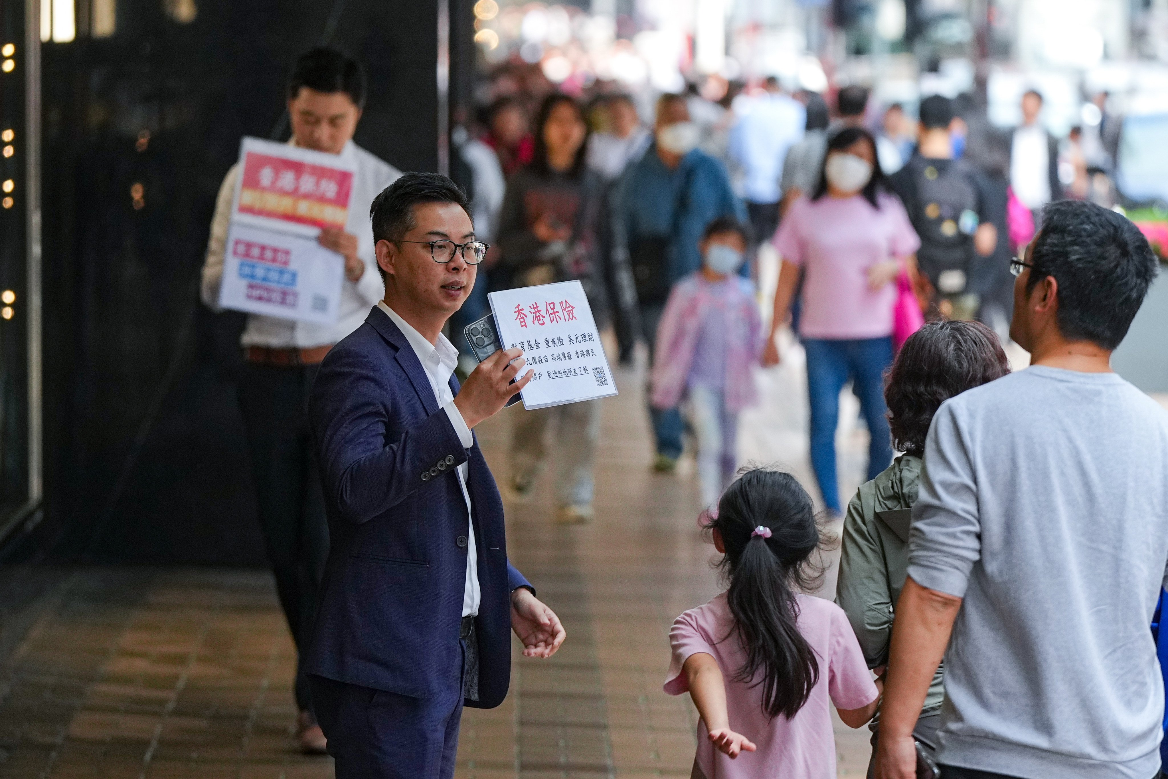 An insurance sales agent approaches mainland tourists in Canton Road, Tsim Sha Tsui. Photo: Eugene Lee