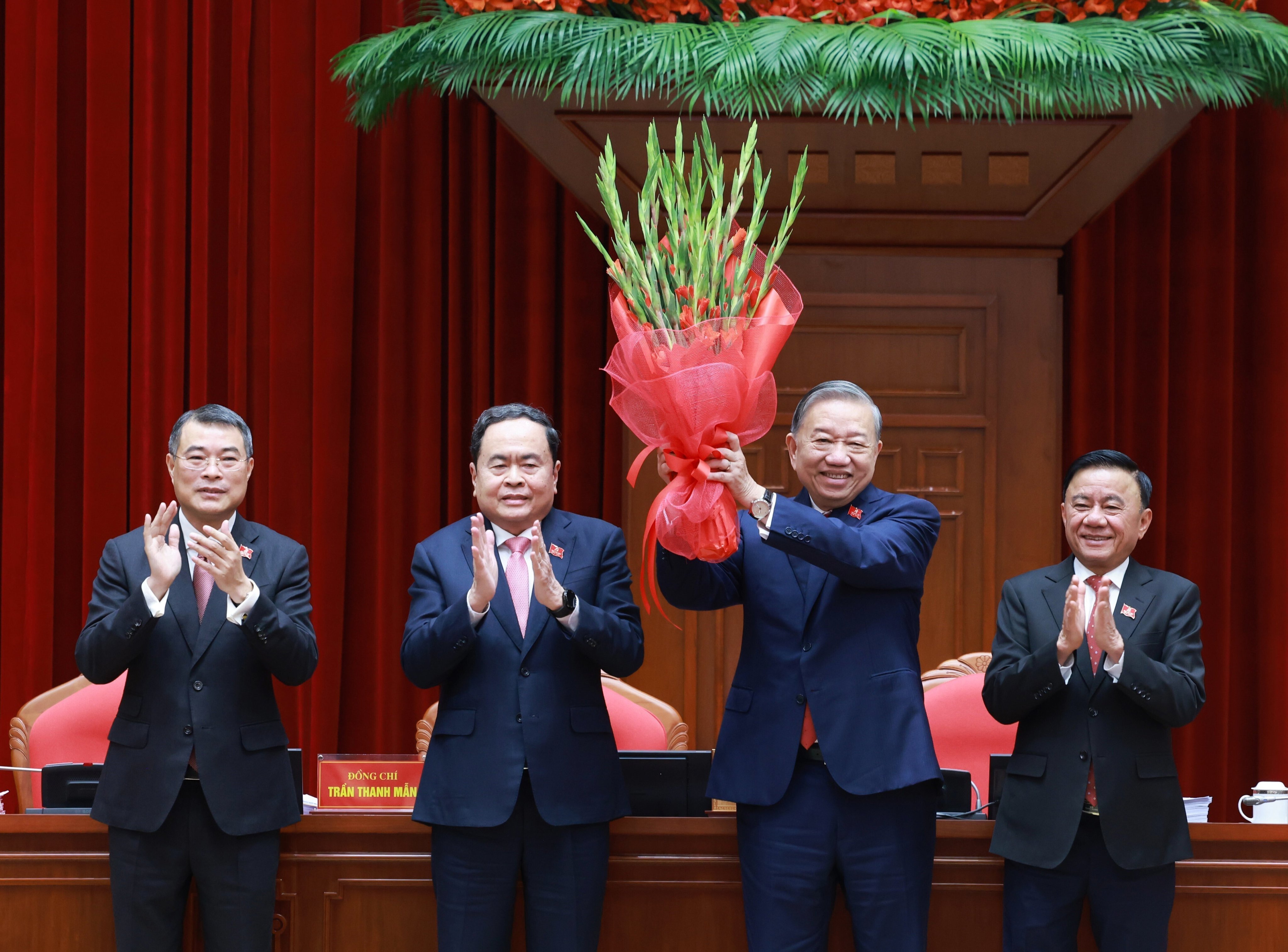 Vietnam’s Communist Party chief To Lam (second right) holds up a bouquet after being re-elected to the position in Hanoi on Friday. Photo: VNA via AP