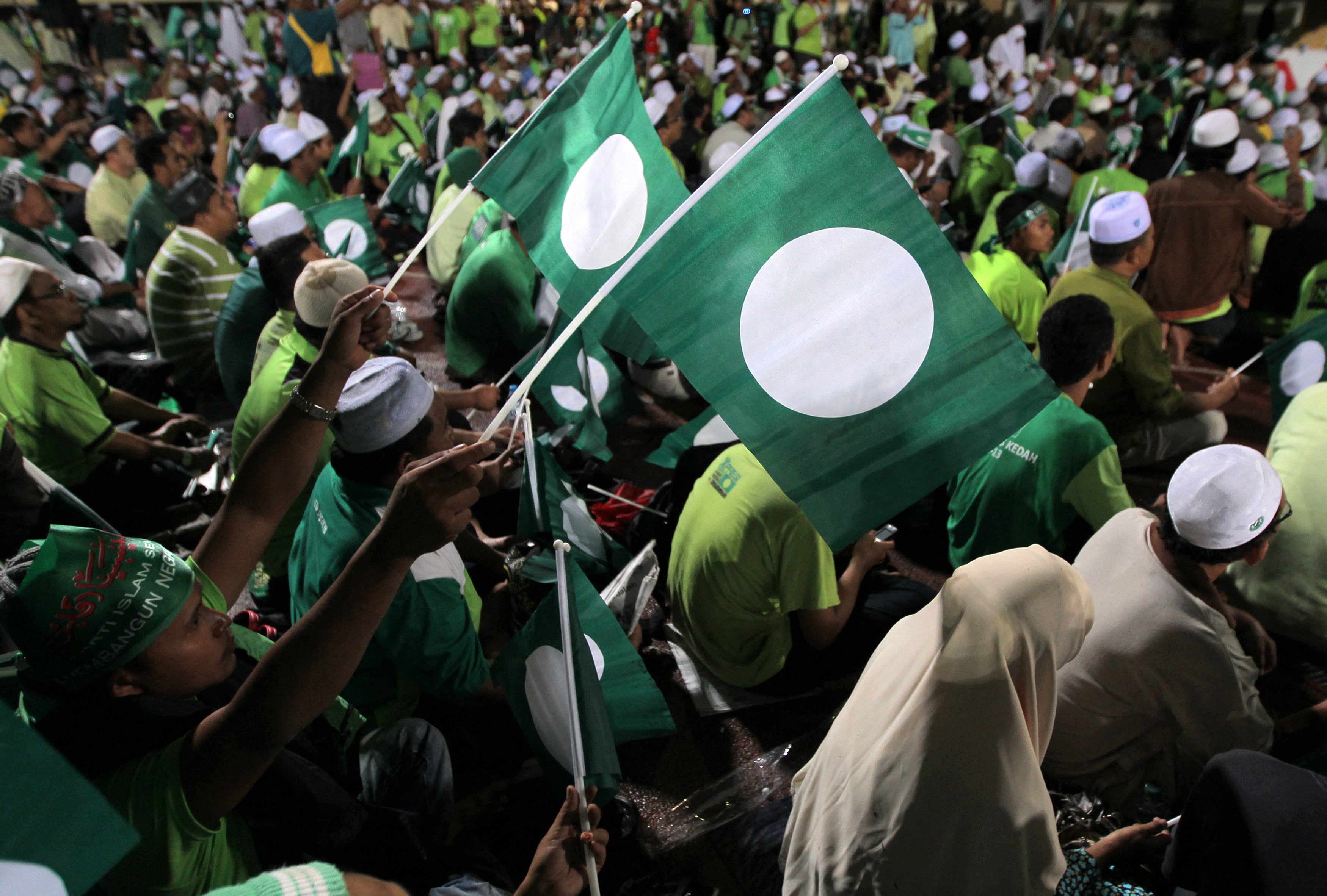 Supporters of the Pan-Malaysian Islamic Party (PAS) wave flags during a rally in Kedah in 2012. Photo: AFP