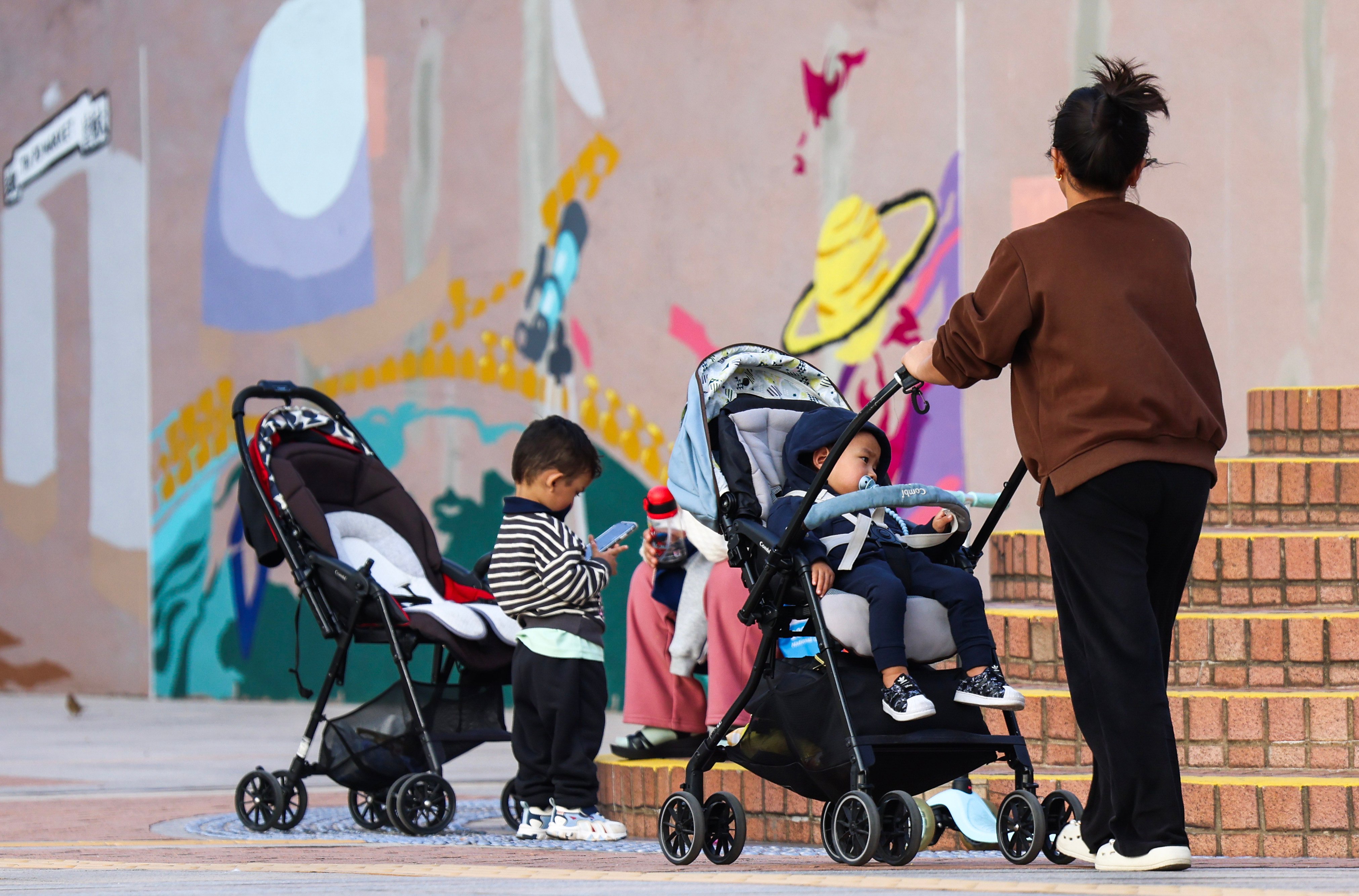 A woman wheels a child in a pram in Tsim Sha Tsui on January 13. Photo: Jelly Tse