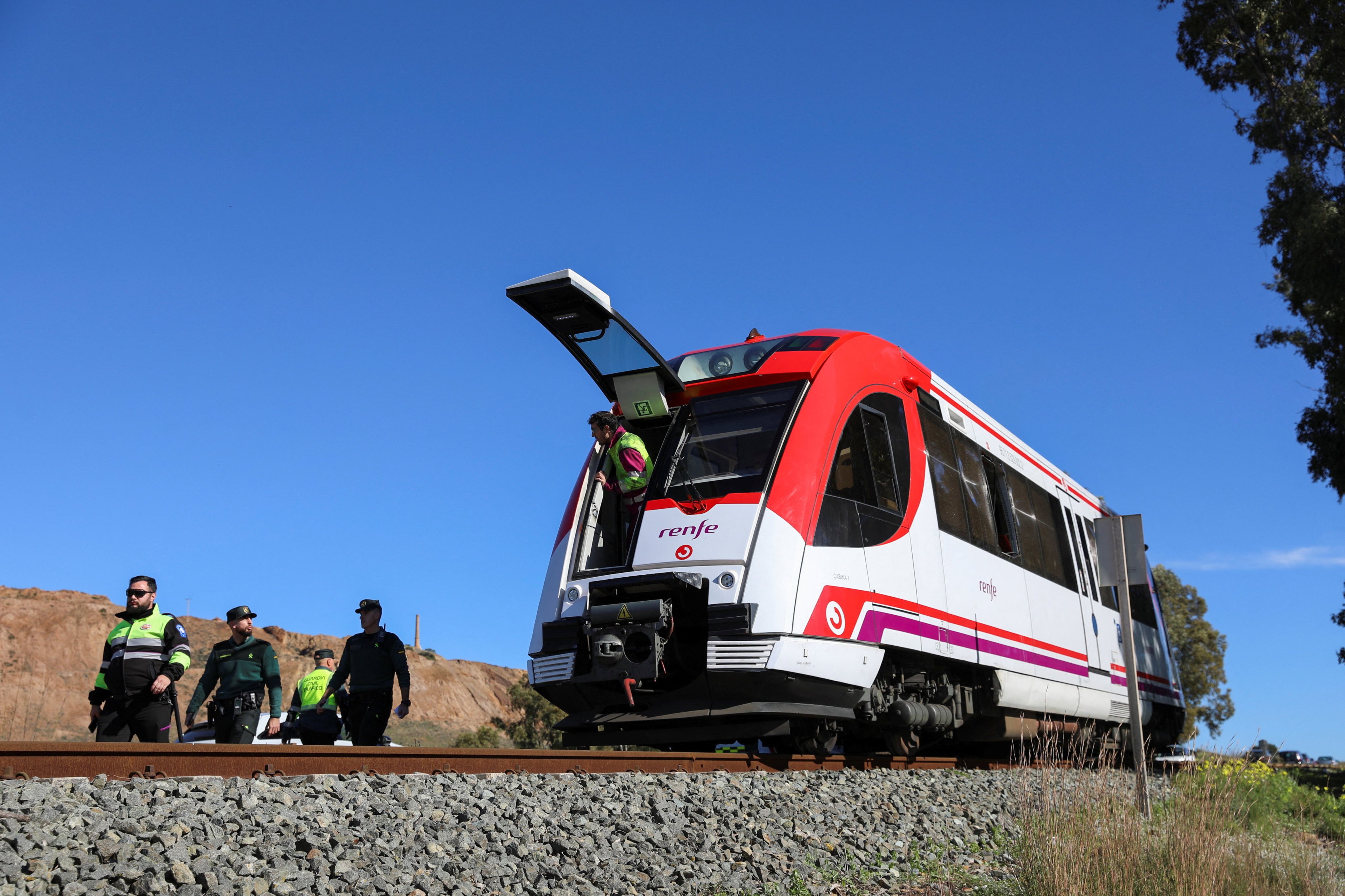 Spanish police forces and first responders examine a commuter train that collided with a crane on Thursday. Photo: Reuters