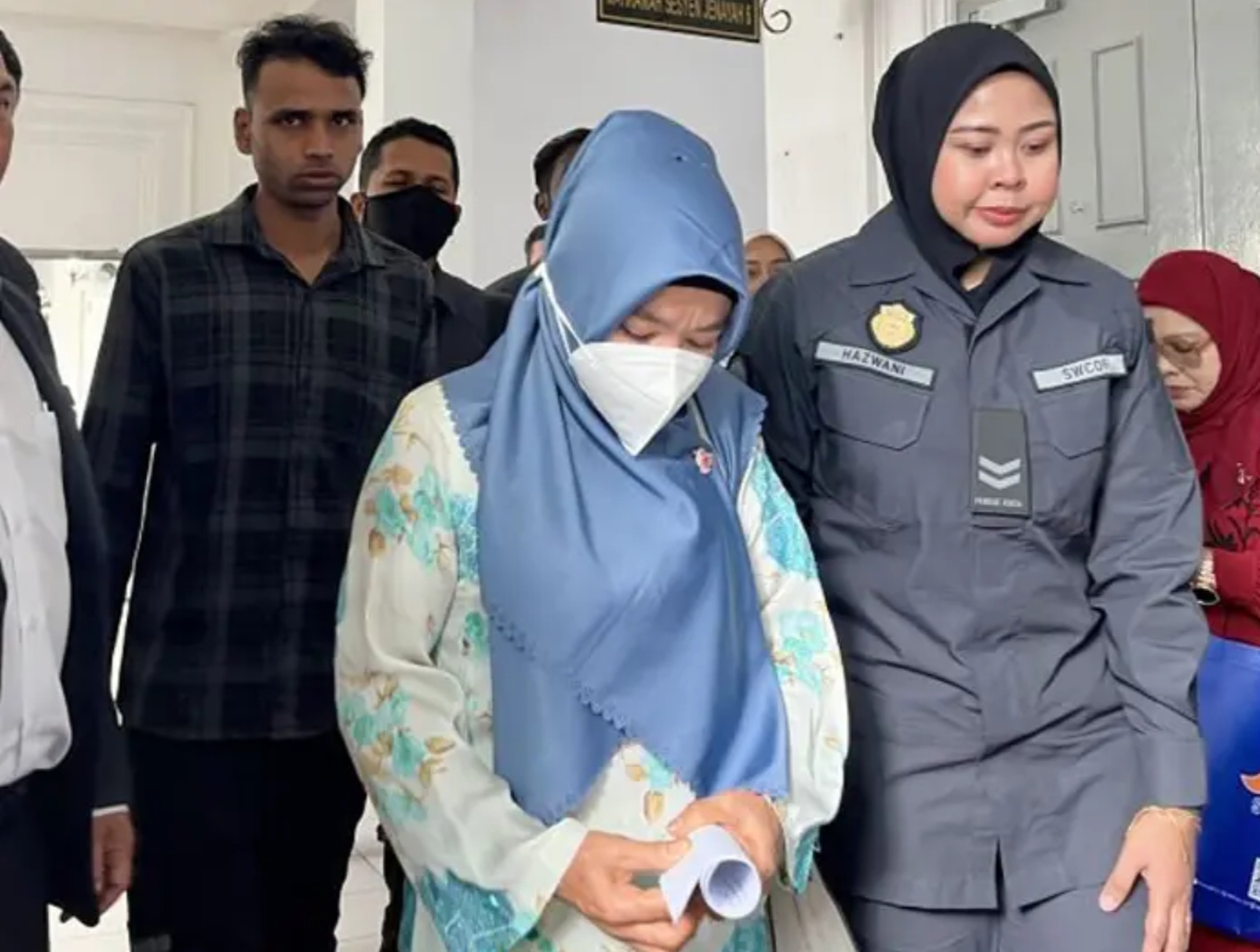 Sultan Md (left) and Anita Lukman (centre) being led into the Sessions Court in Johor Bahru where they were charged with littering in public. Photo: The Star