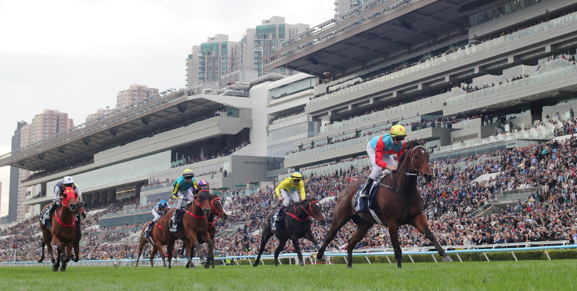Raging Blizzard (blue, yellow and black) finishes second to Ka Ying Rising. Raging Blizzard (blue, yellow and black) finishes second to Ka Ying Rising.