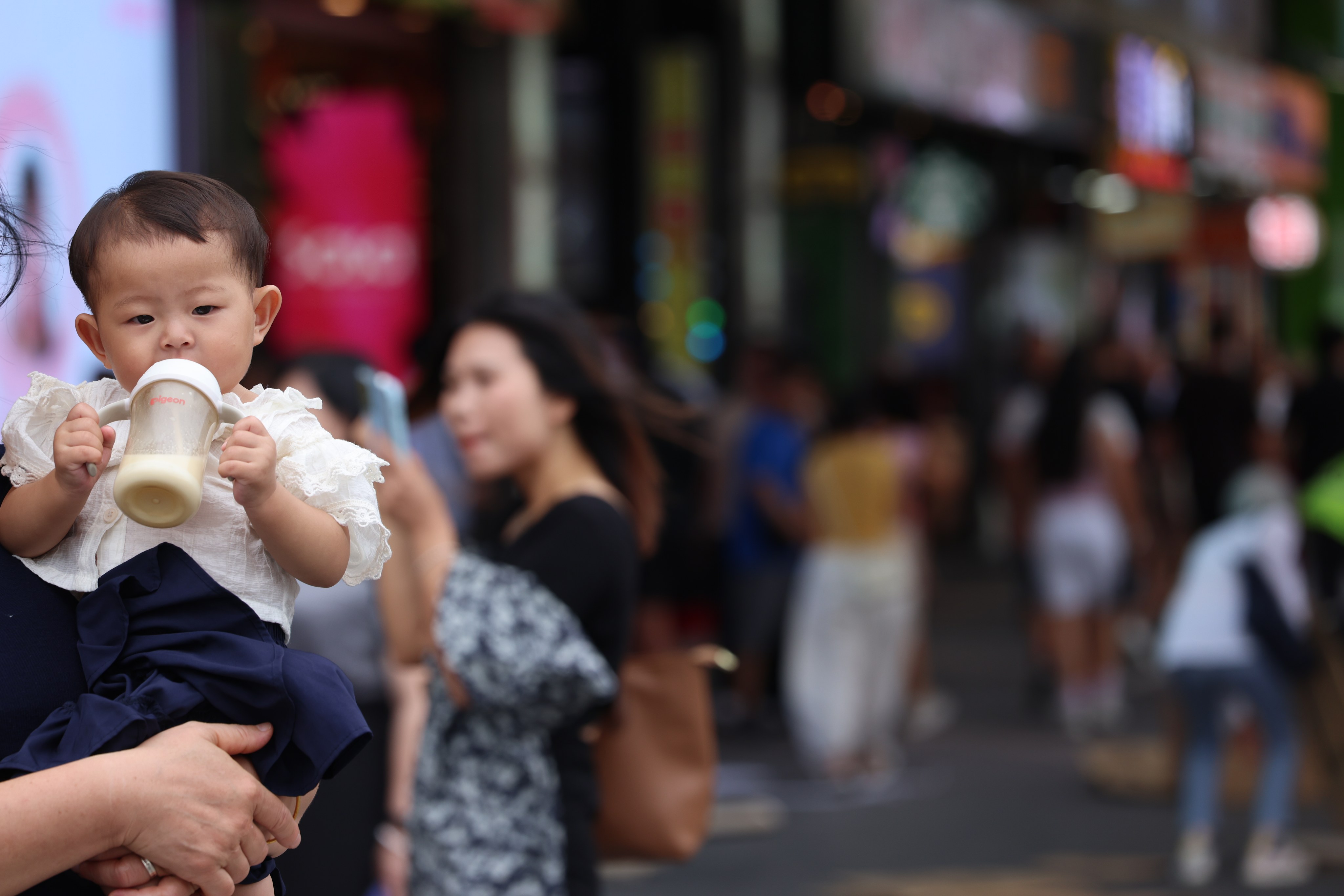 A baby drinks milk in Hong Kong’s Tsim Sha Tsui district on September 19, 2025. Economic pressures such as the cost of living and work-life imbalance make parenting challenging. Photo: Jelly Tse