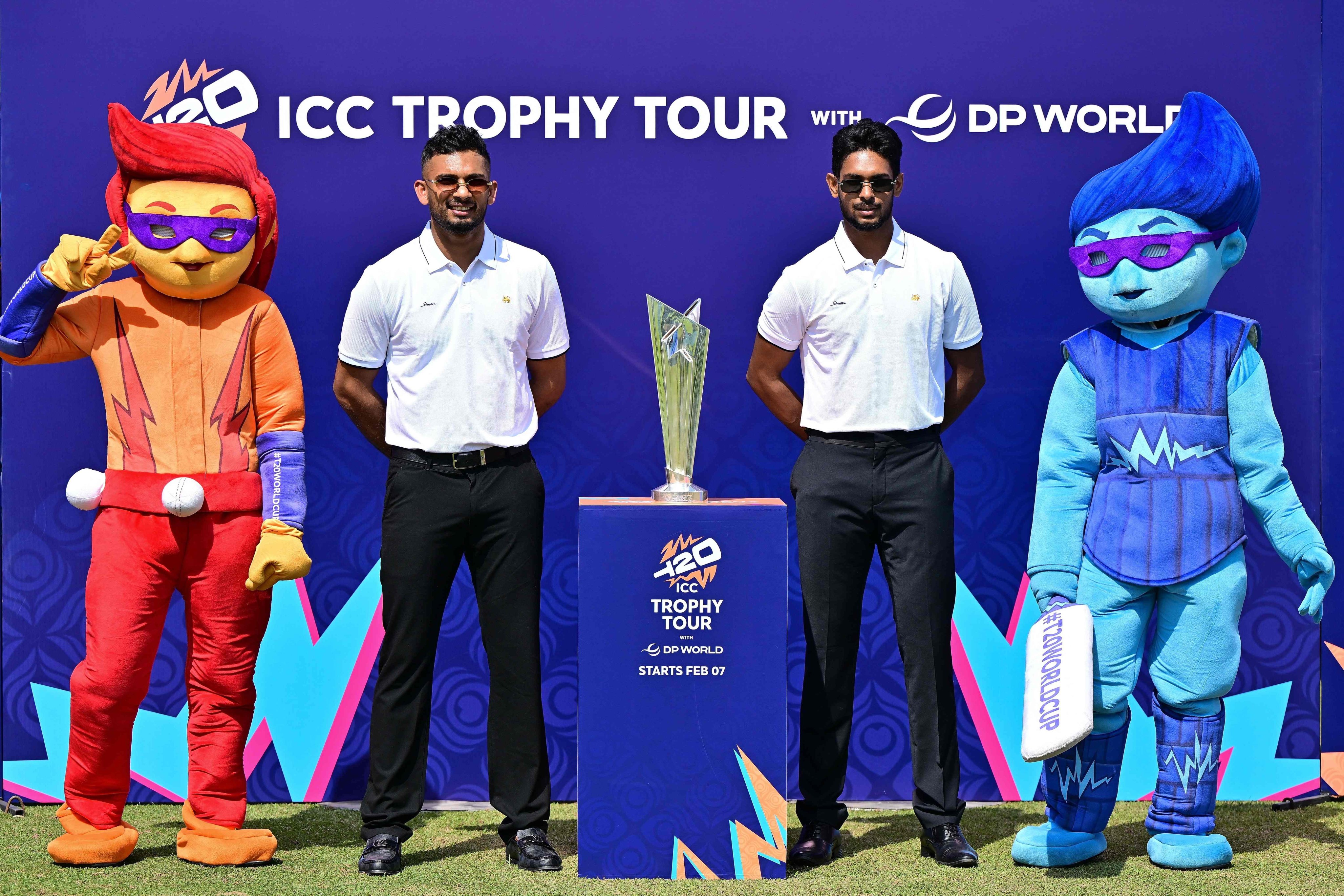 Sri Lank captain Dasun Shanaka (left) and teammate Matheesha Pathirana pose with mascots and the T20 Cricket World Cup trophy during an unveiling event at the Sinhalese Sports Club stadium in Colombo on Friday. Photo: AFP