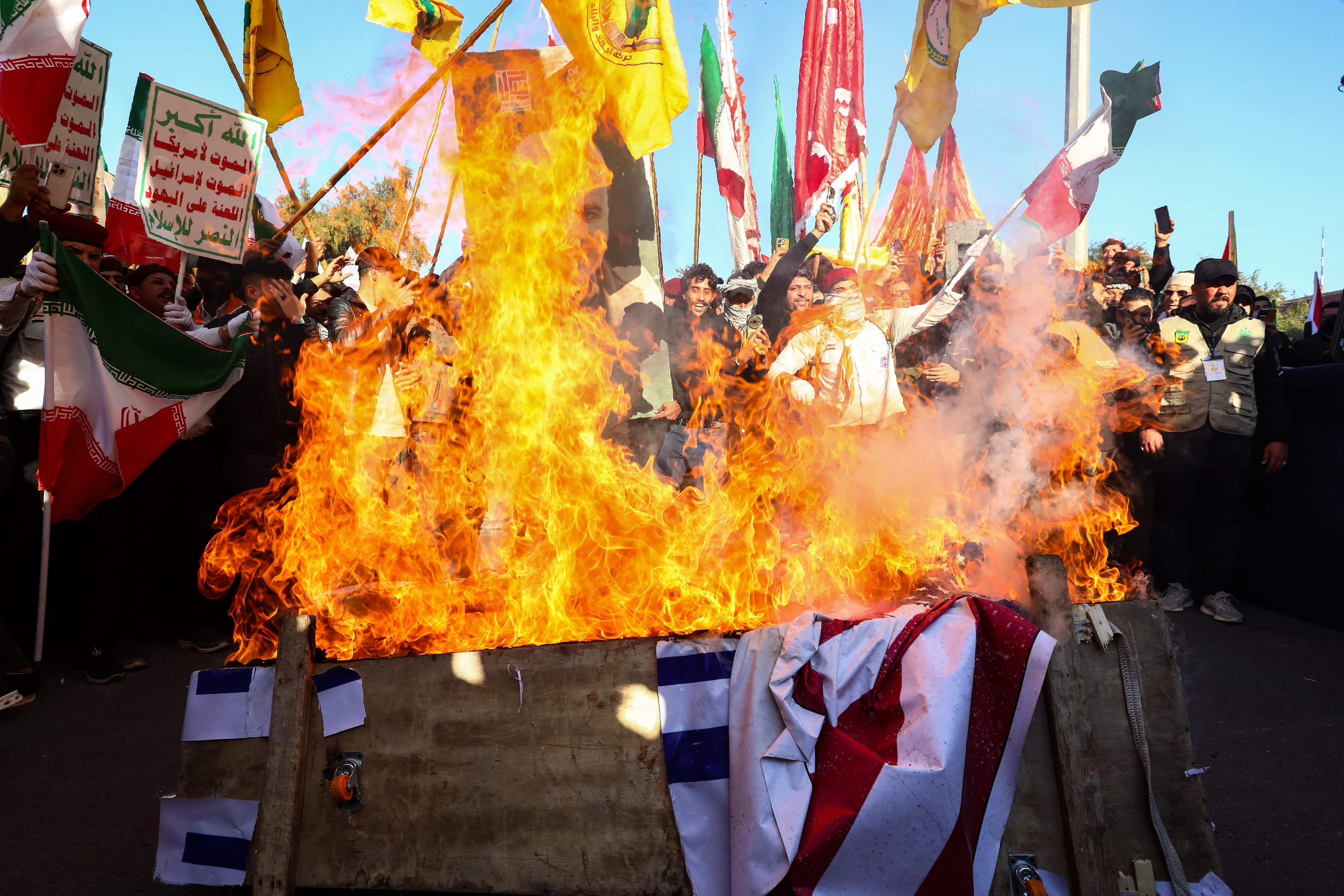 Iraqi demonstrators burn a symbolic coffin wrapped with the flags of the US and Israel, during a demonstration in front of the Iranian Embassy in Baghdad, to show solidarity with Iran against US threats, on January 16. Photo: dpa