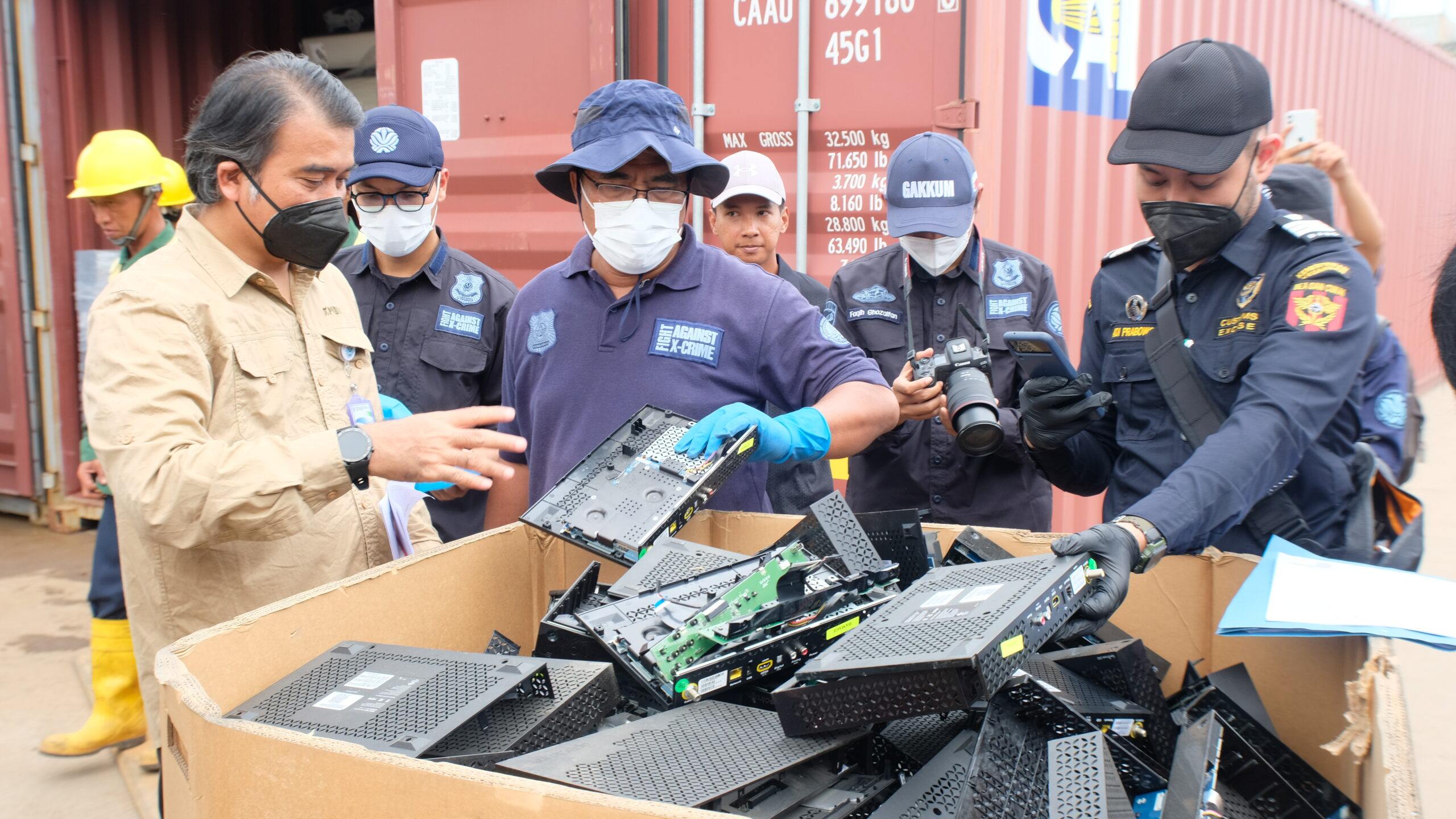 Indonesian customs and environmental enforcement officers inspect discarded electronic equipment seized from containers at Batu Ampar port in Batam in October. Photo: Batam Customs
