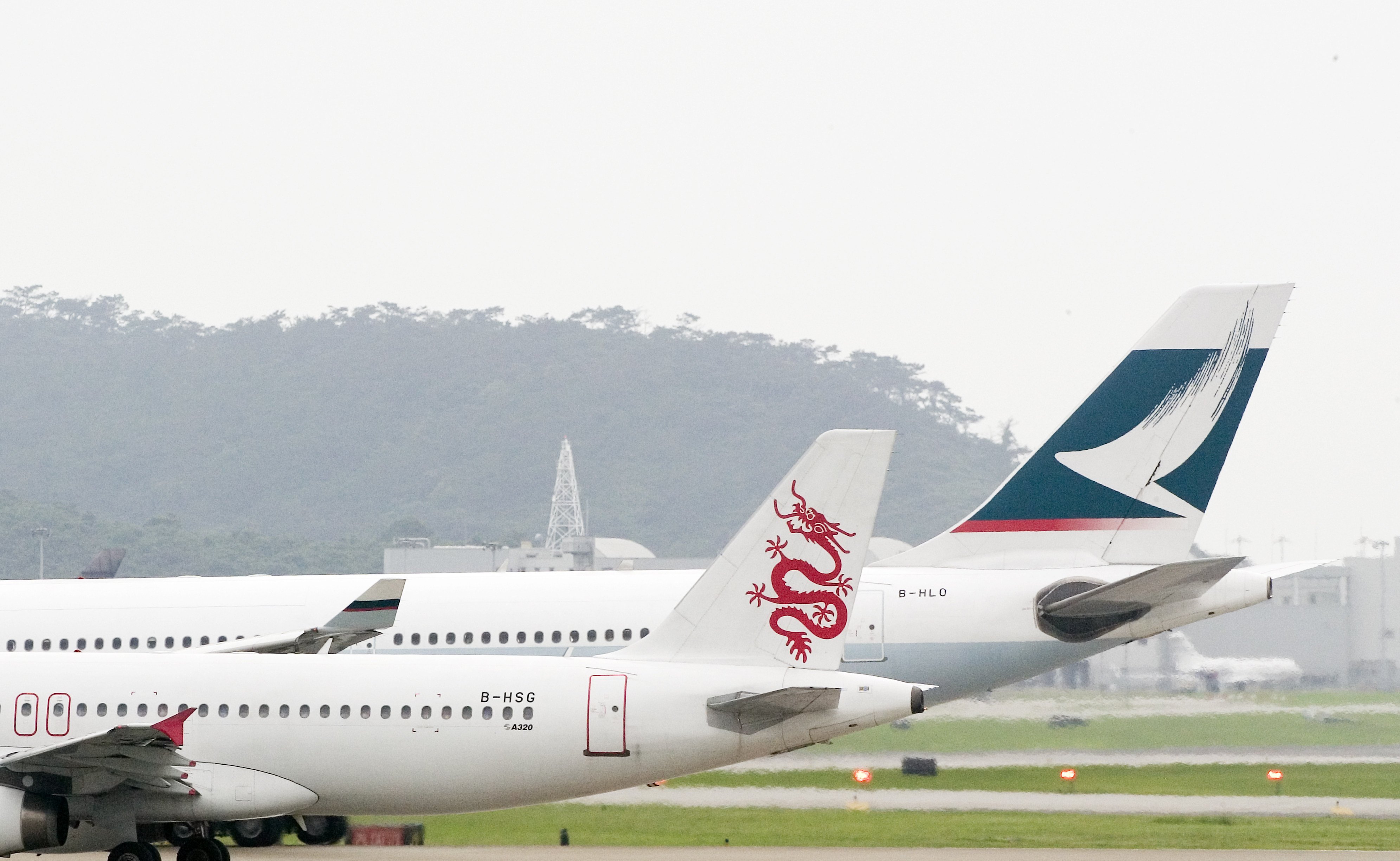 A Dragonair plane sits besides a Cathay Pacific plane on Hong Kong’s Chek Lap Kok airport tarmac on June 7, 2006. Photo: SCMP