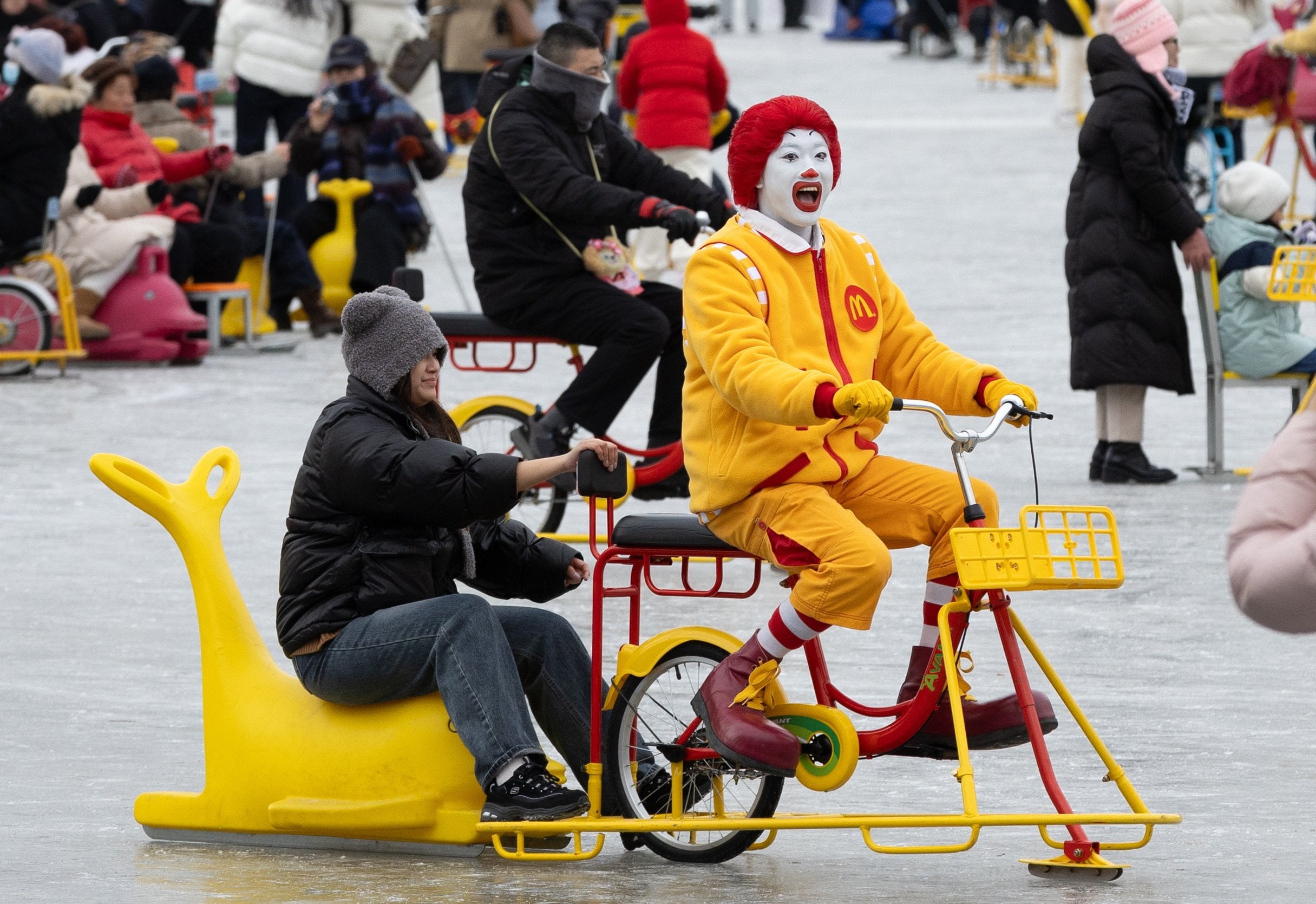 A person dressed as McDonald’s mascot Ronald McDonald skate-bikes on a frozen lake in Beijing, China. Photo: EPA