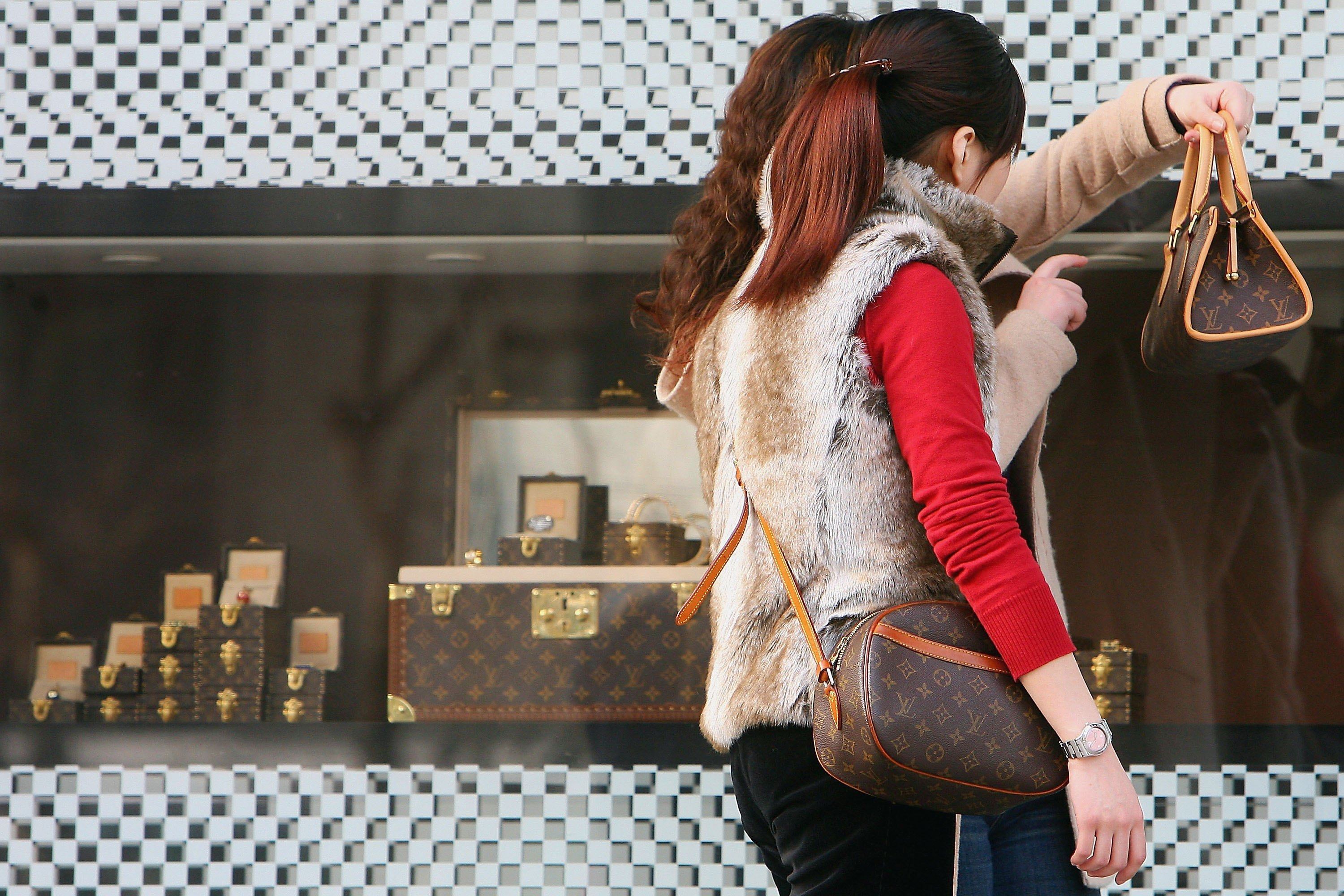Two shoppers view the handbags they just bought at a Louis Vuitton store in Shanghai. China’s luxury market is showing signs of recovery after a sharp decline in sales in 2024. Photo: Getty Images
