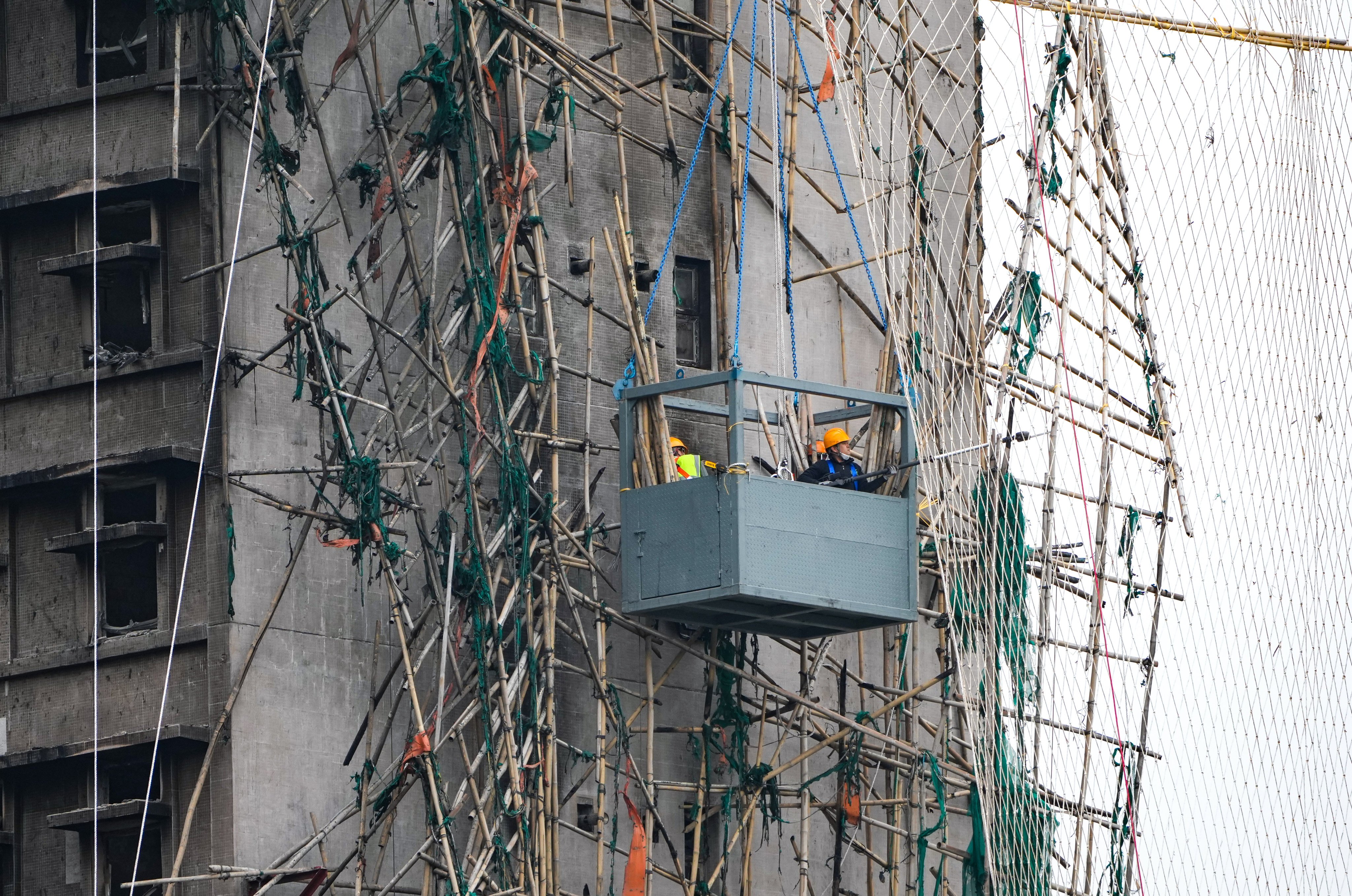 Workers remove damaged bamboo scaffolding at Wang Fuk Court in Tai Po, on January 21. Photo: Sam Tsang