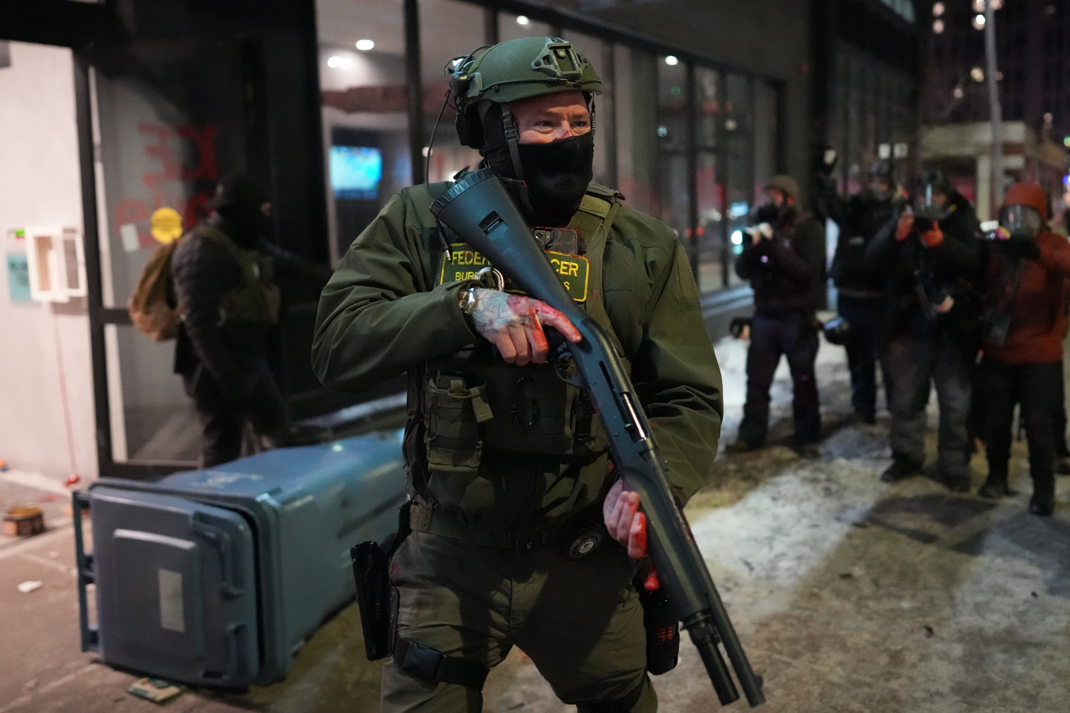 A US federal agent stands guard during a protest in Minneapolis on Sunday. Photo: AP