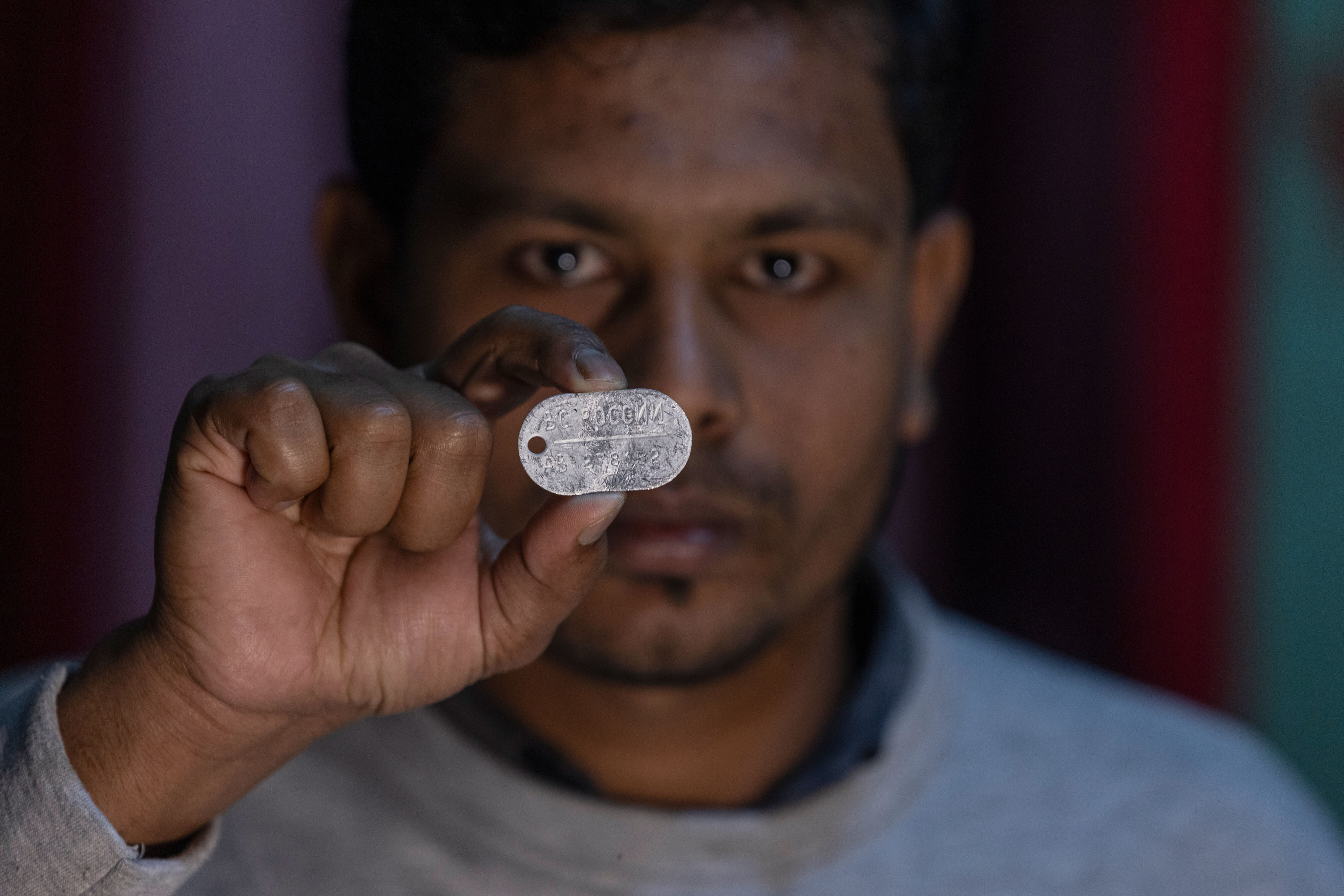 Maksudur Rahman, 31, who escaped after fighting for the Russian army, shows a Russian military dog tag during an interview with The Associated Press in Lakshmipur, Bangladesh,  Dec. 10, 2025. (AP Photo/Rajib Dhar)